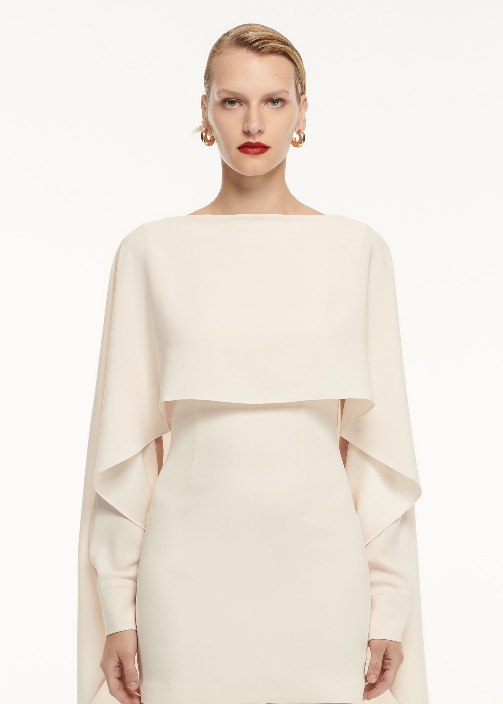 A close up of a woman wearing the Long Sleeve Satin Crepe Mini Dress Cream