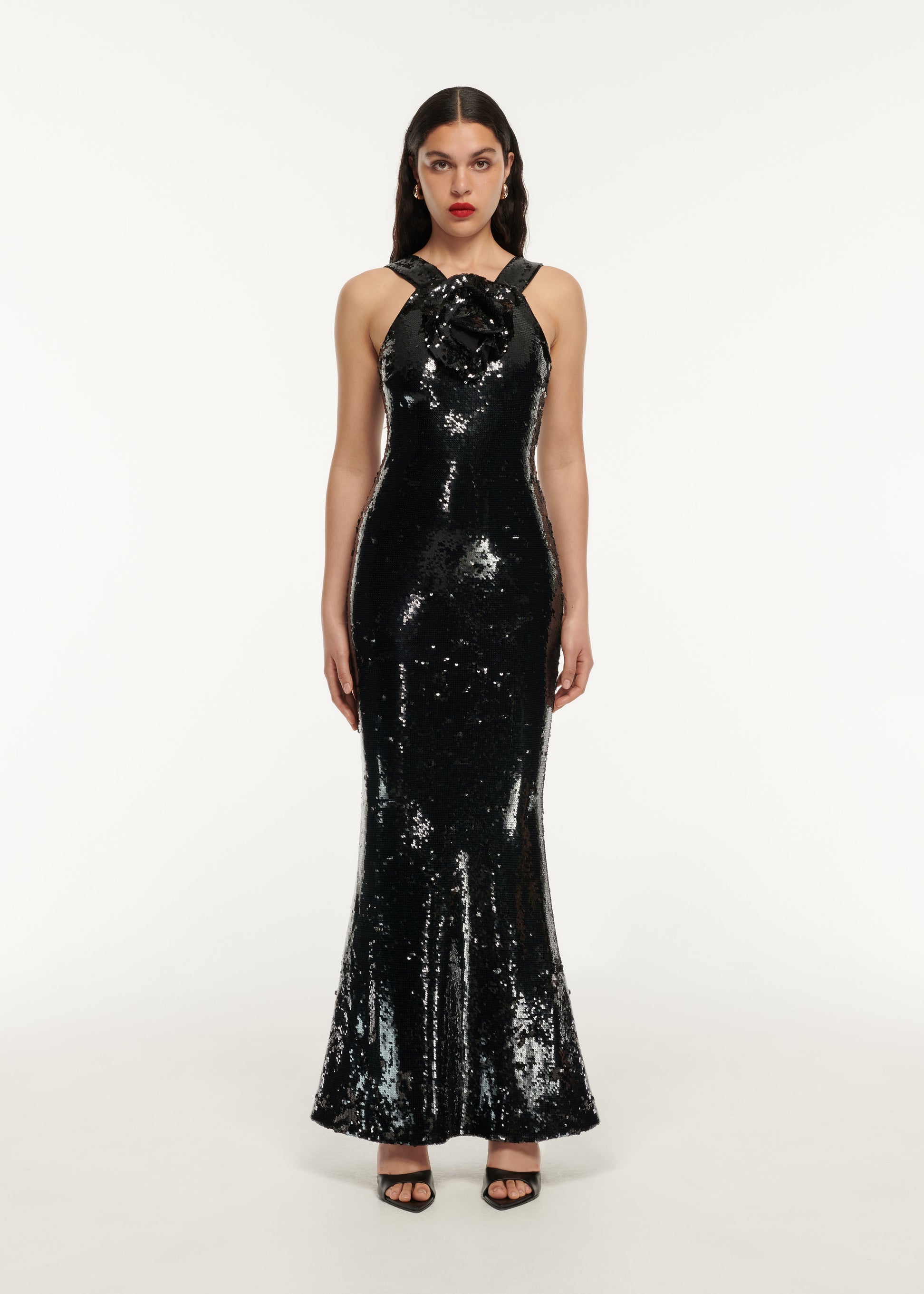 A woman wearing the Sequin Flower Drape Maxi Dress in Black