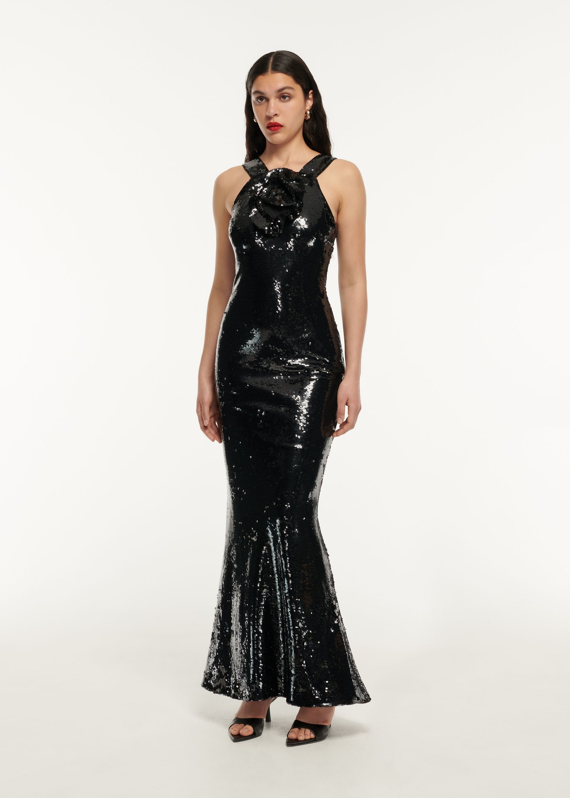 A woman wearing the Sequin Flower Drape Maxi Dress in Black