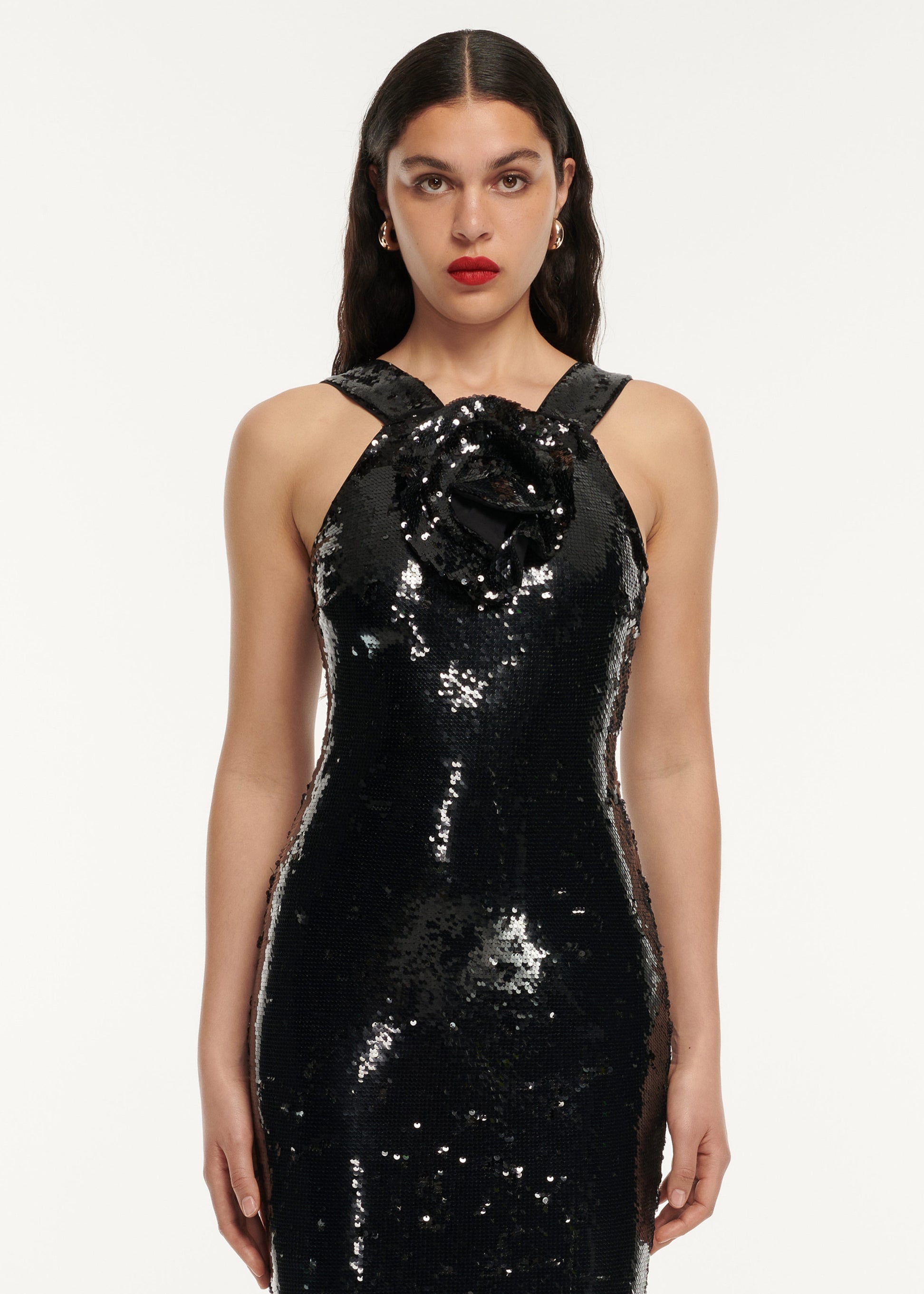 A close up of a woman wearing the Sequin Flower Drape Maxi Dress