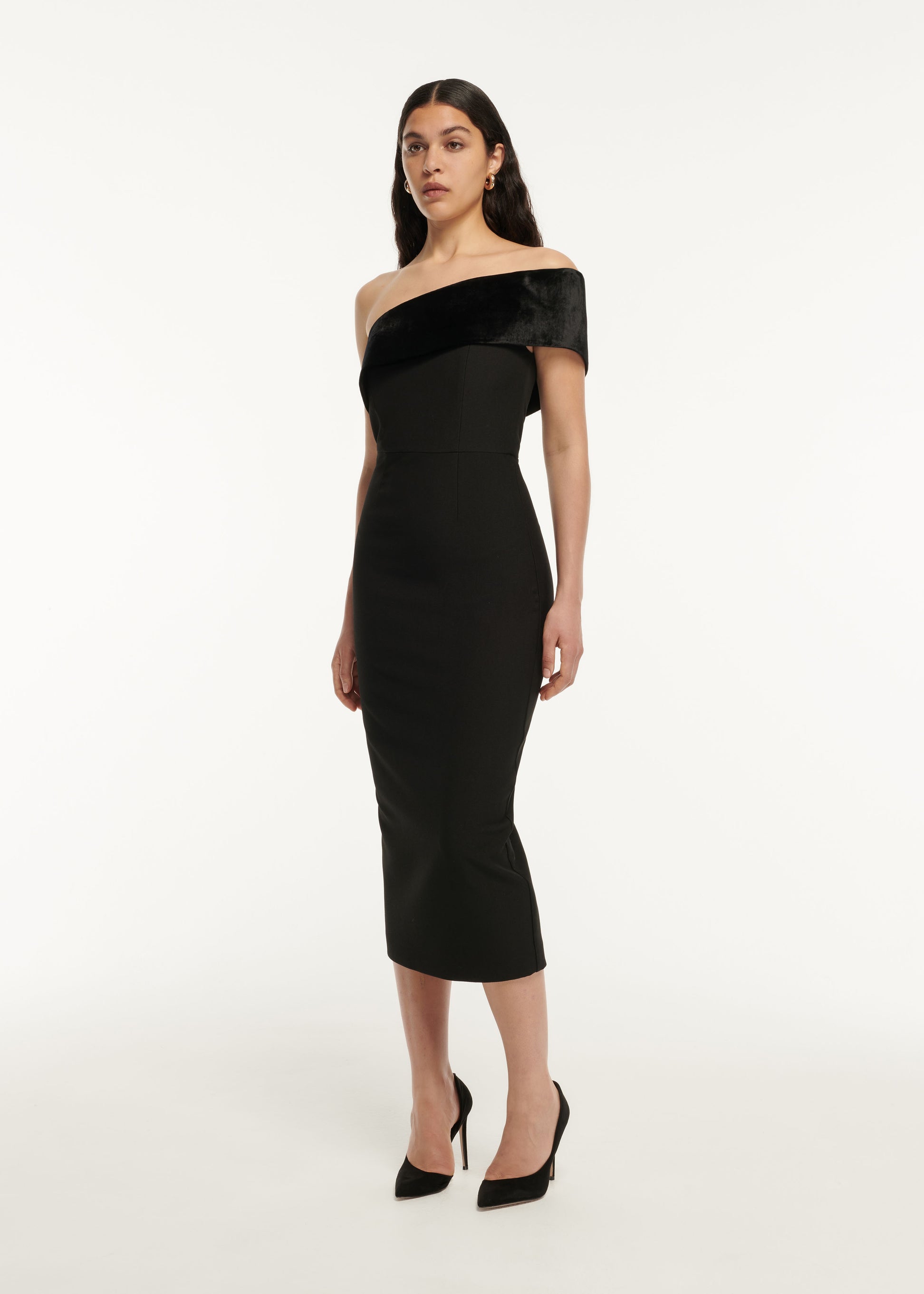 A woman wearing the Asymmetric Stretch Cady Midi Dress in Black
