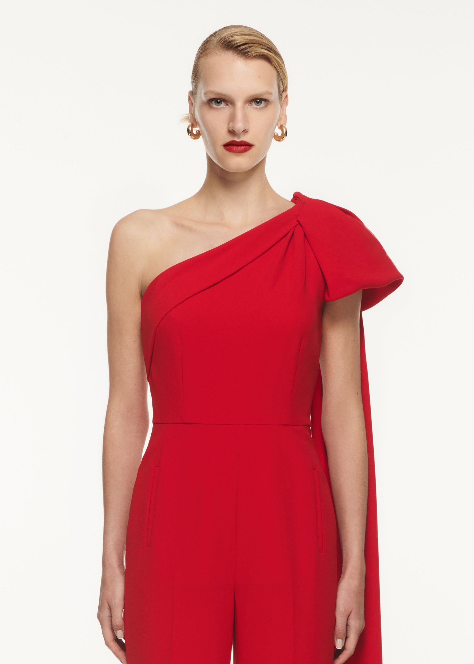 A close up of a woman wearing the Asymmetric Bow Stretch Cady Jumpsuit