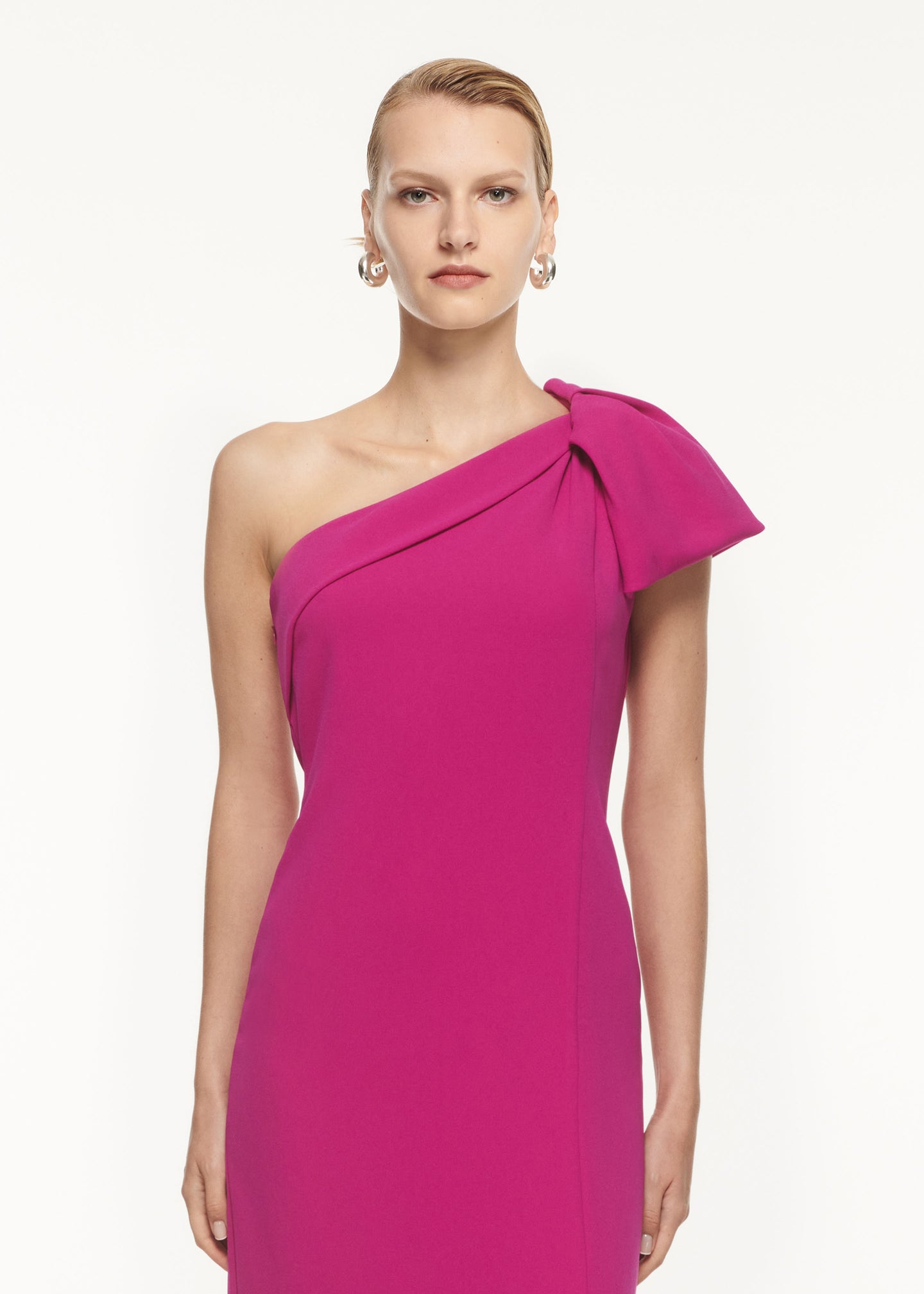 A close up of a woman wearing the Asymmetric Bow Stretch Cady Maxi Dress