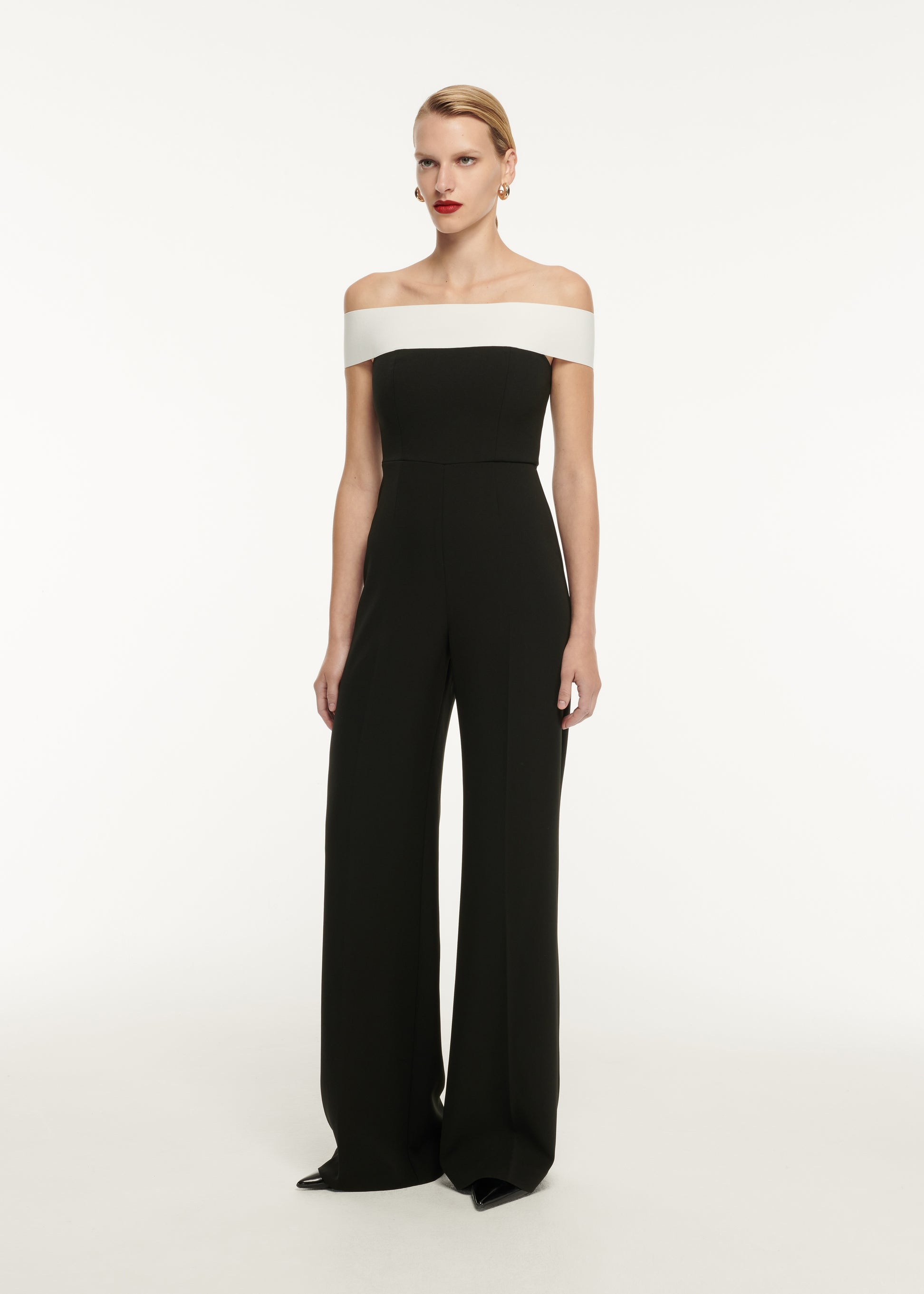 A woman wearing the Off The Shoulder Stretch Cady Jumpsuit