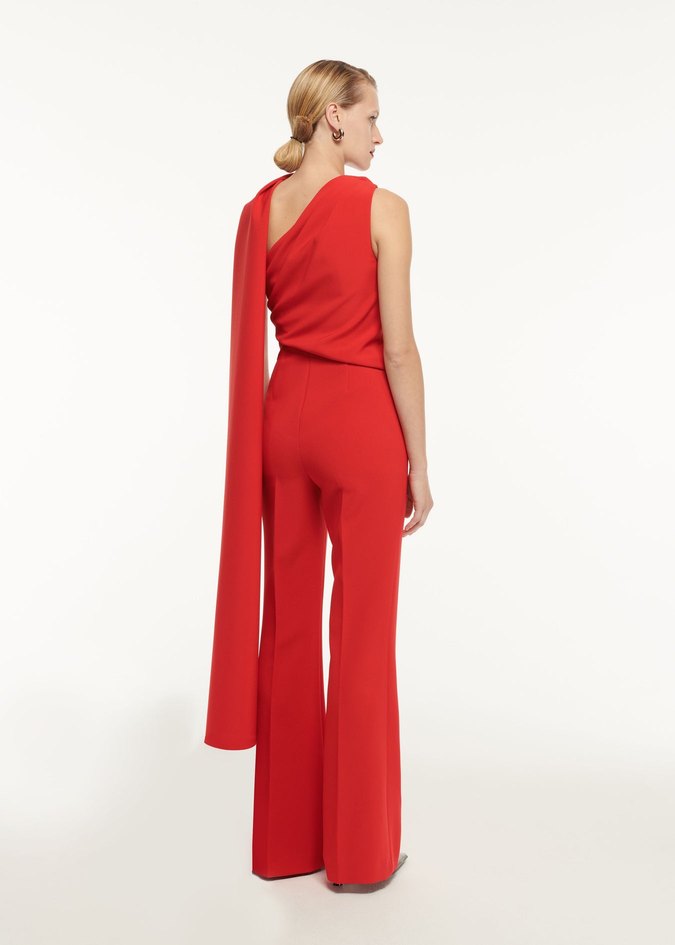The back of a woman wearing the Asymmetric Bow Stretch Cady Jumpsuit
