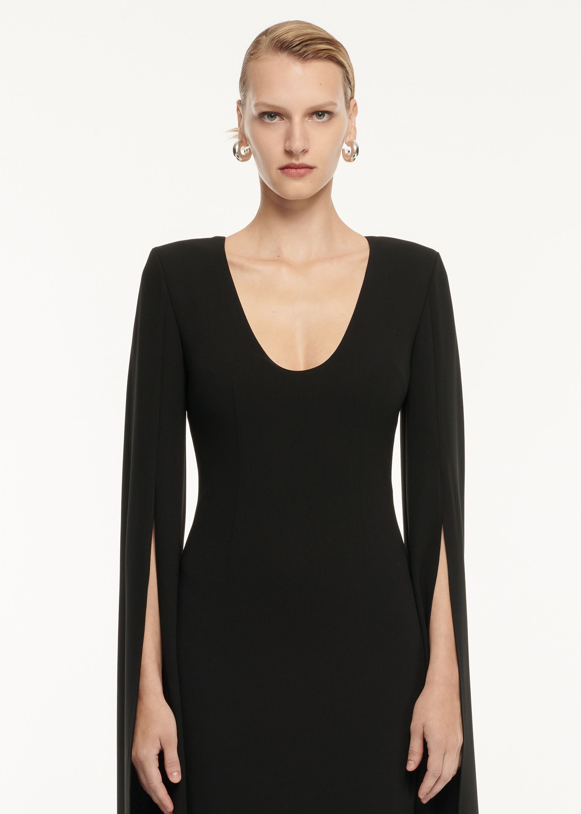 A close up of a woman wearing the Cape Sleeve Stretch Cady Maxi Dress