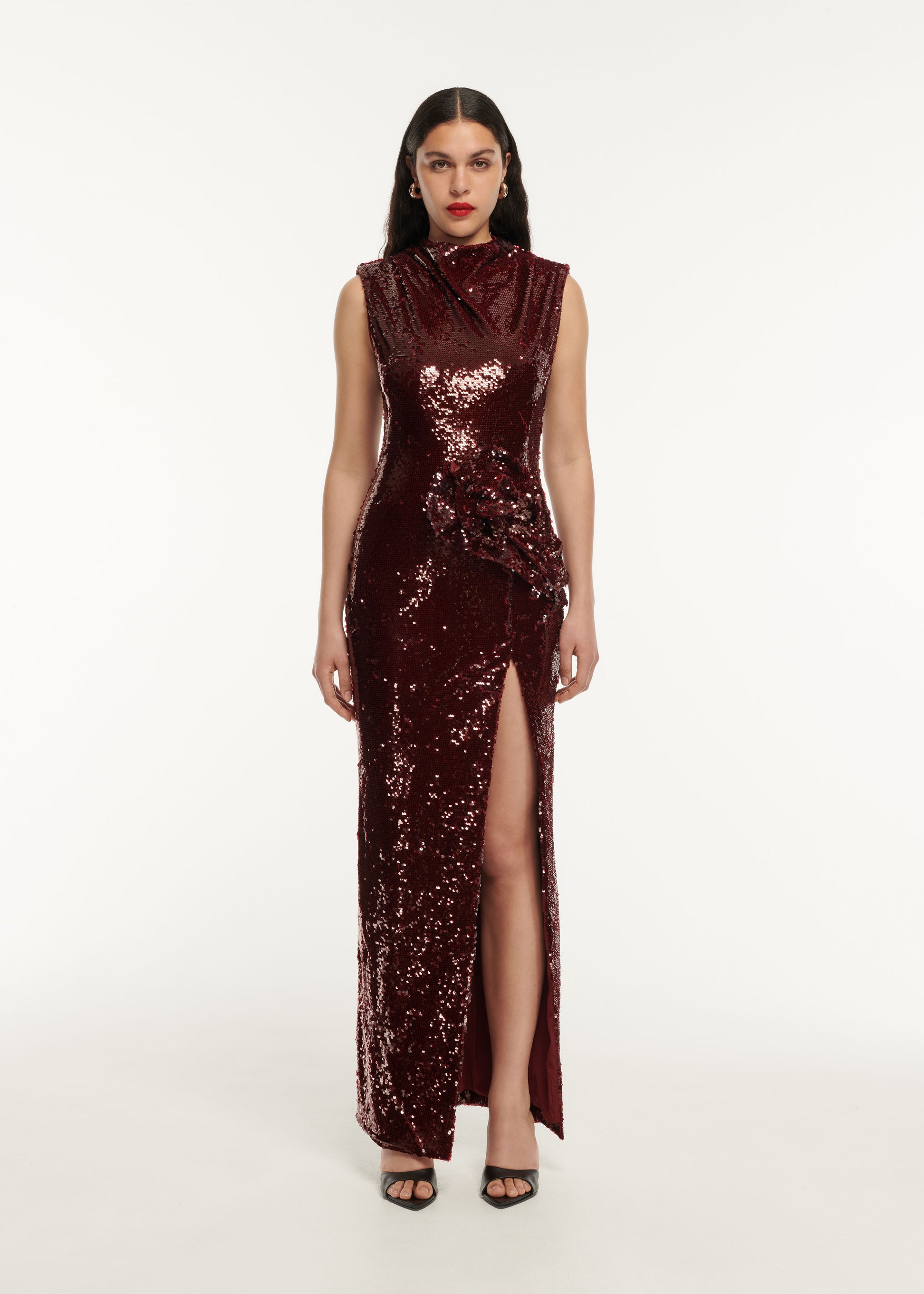 A woman wearing the Sequin Drape Maxi Dress in Maroon
