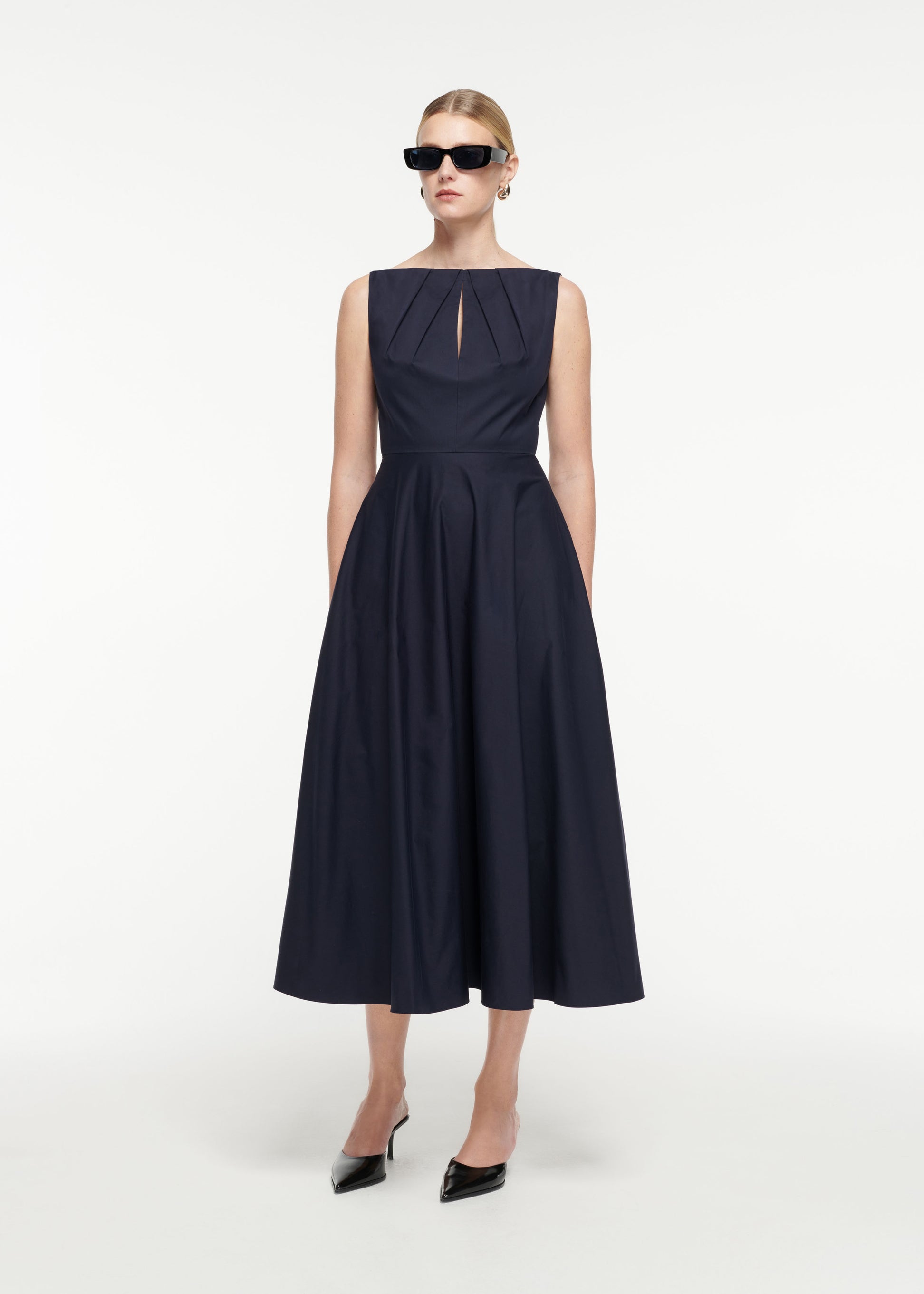 Side view of a model wearing the Cotton Poplin Midi Dress in Navy
