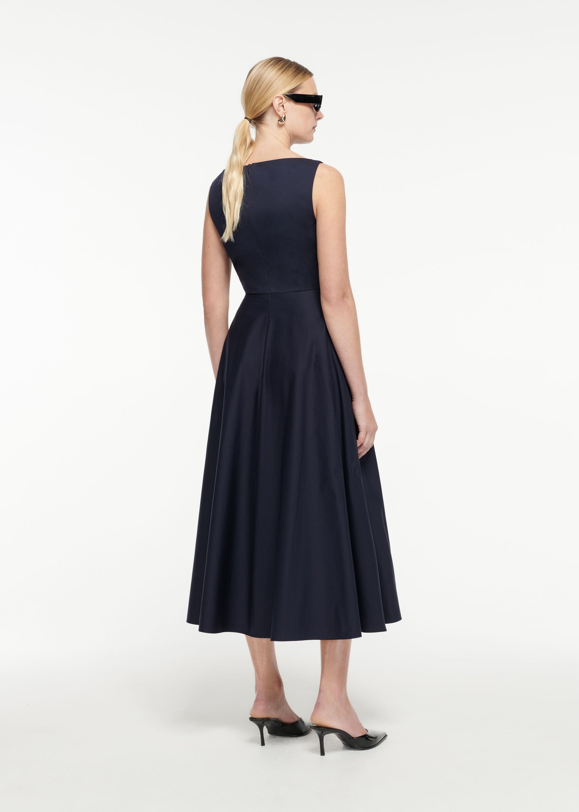 Back view of a model wearing the Cotton Poplin Midi Dress in Navy