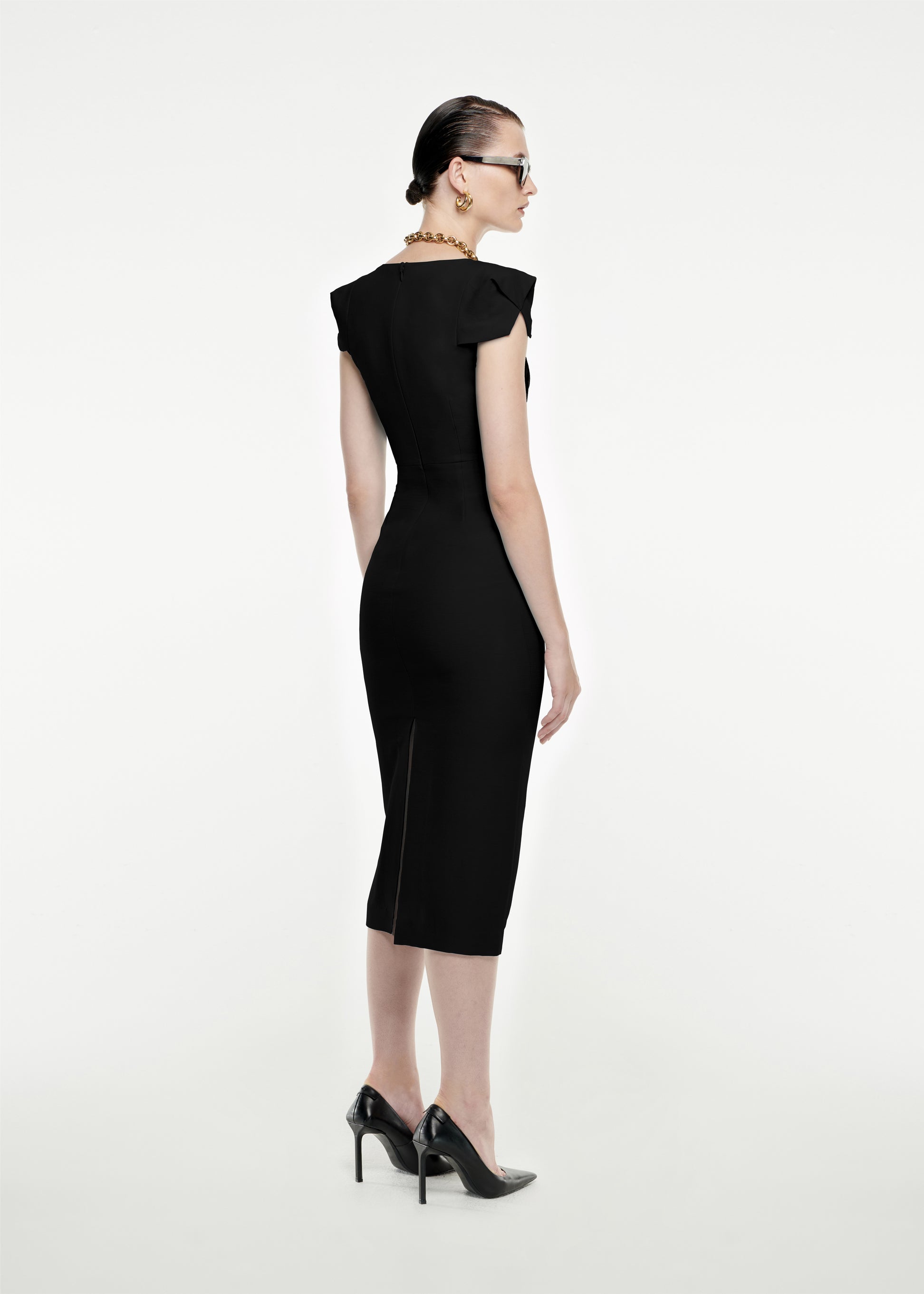 The back of a woman wearing the Cap Sleeve Silk Wool Midi Dress in Black