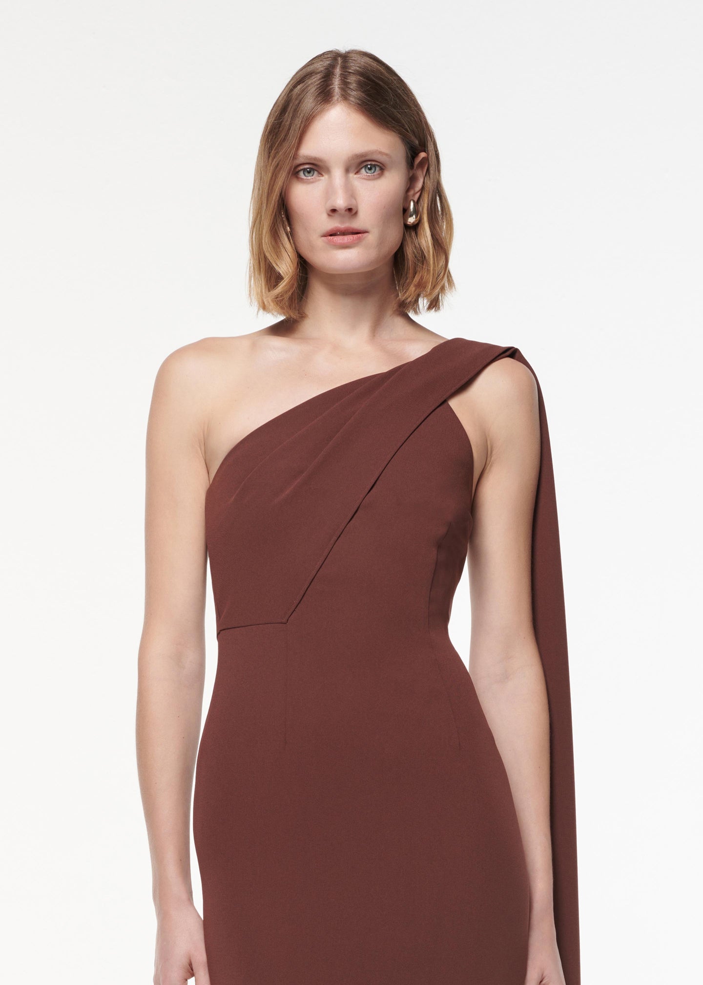 A photograph of a woman wearing a Asymmetric Heavy Cady Midi Dress in Brown