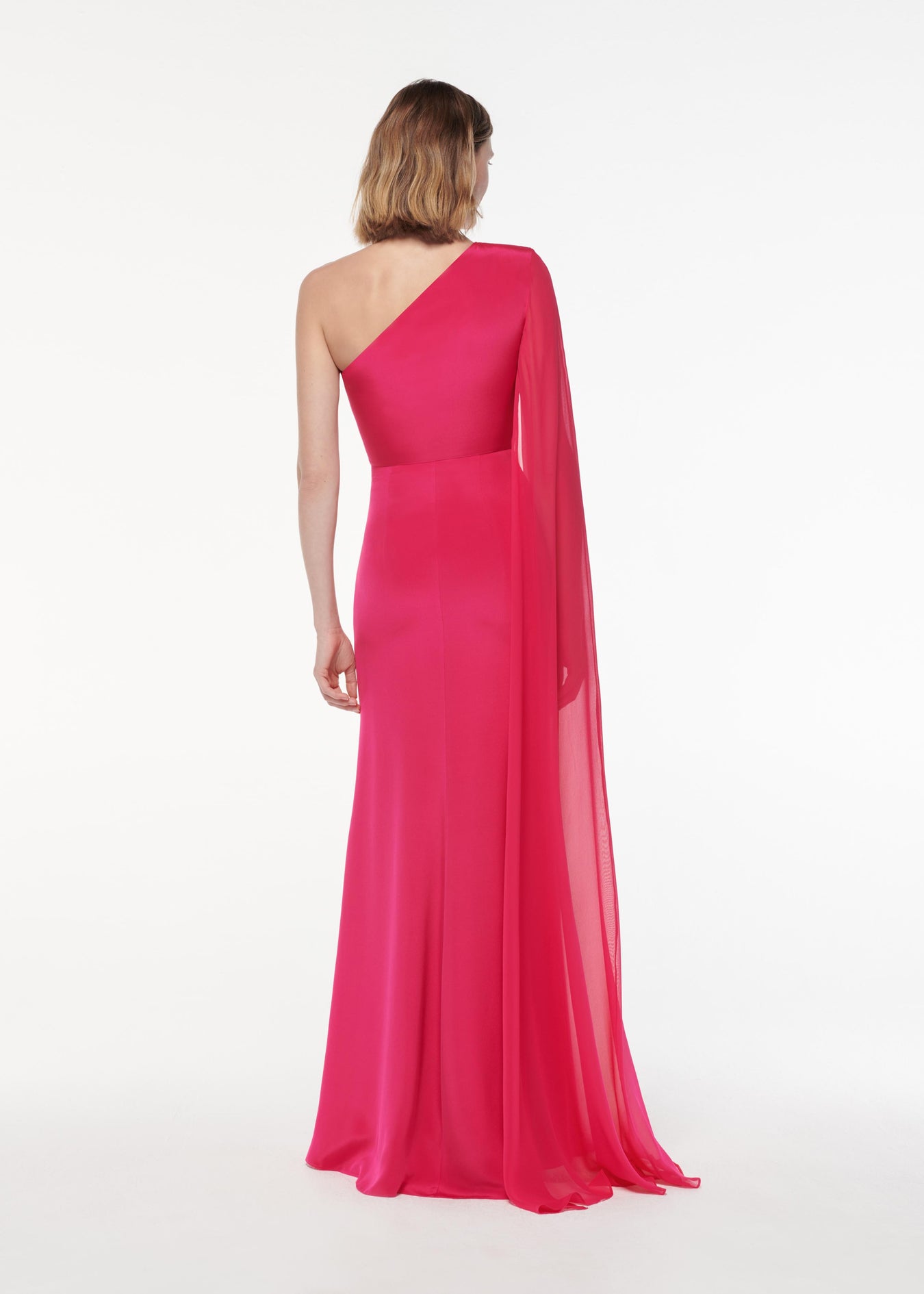 A photograph of a woman wearing a Asymmetric Silk Gown in Pink