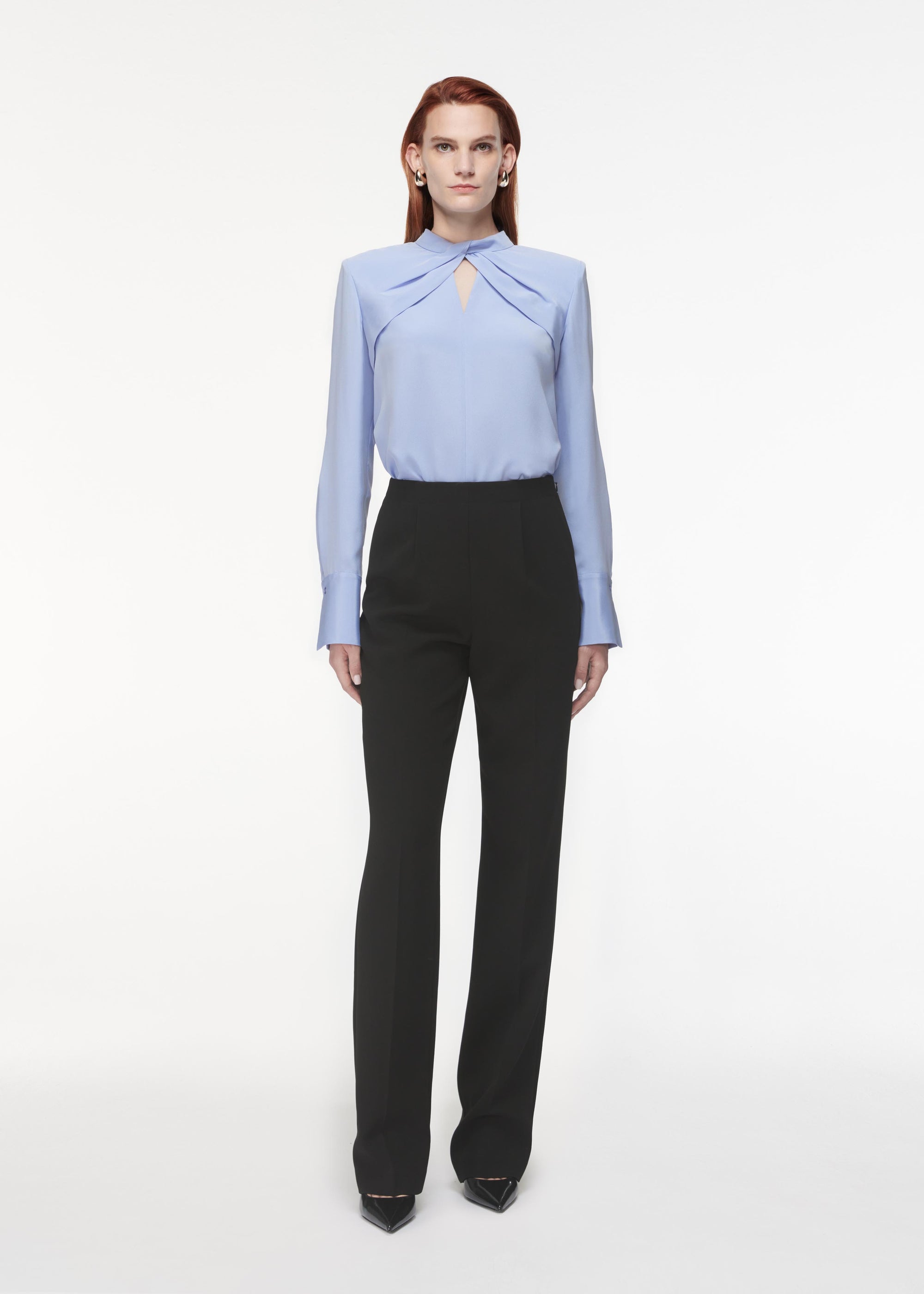 A photograph of a woman wearing a Silk Twist Top in Blue