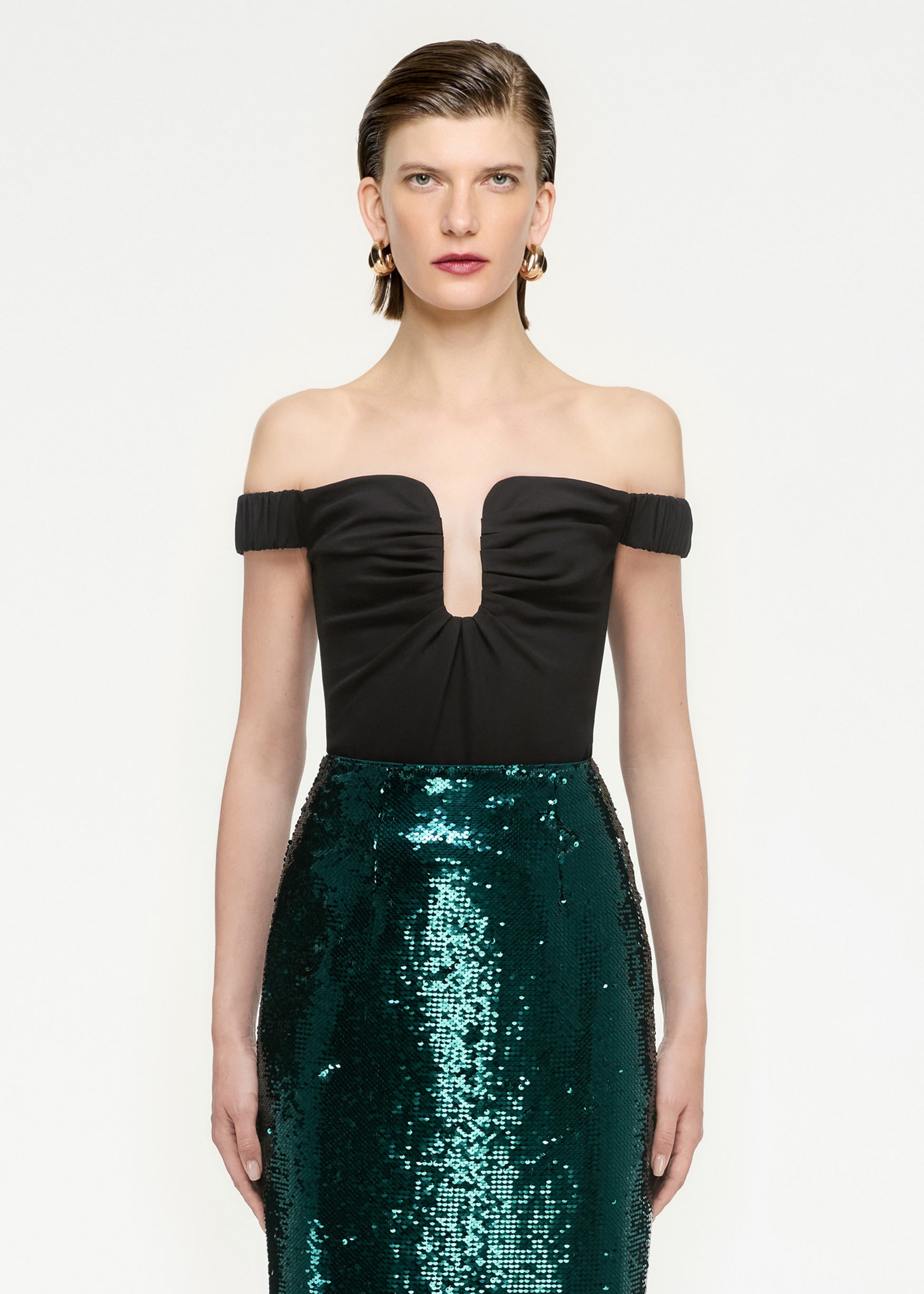 A close up of a woman wearing the Sequin Midi Skirt in Green