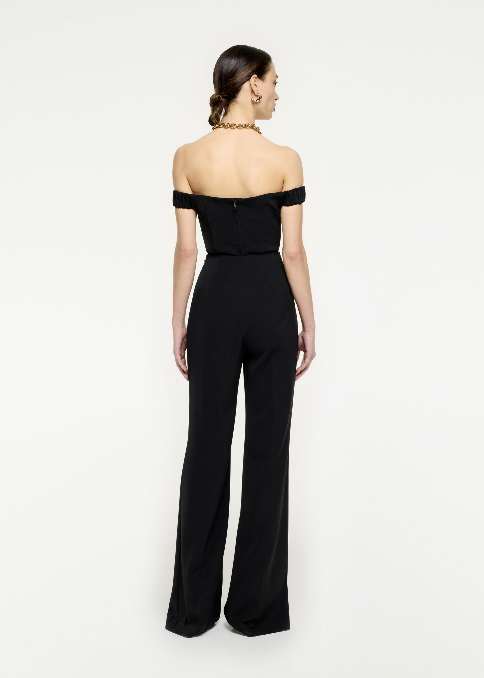 The back of a woman wearing the Off The Shoulder Stretch Cady Top in Black