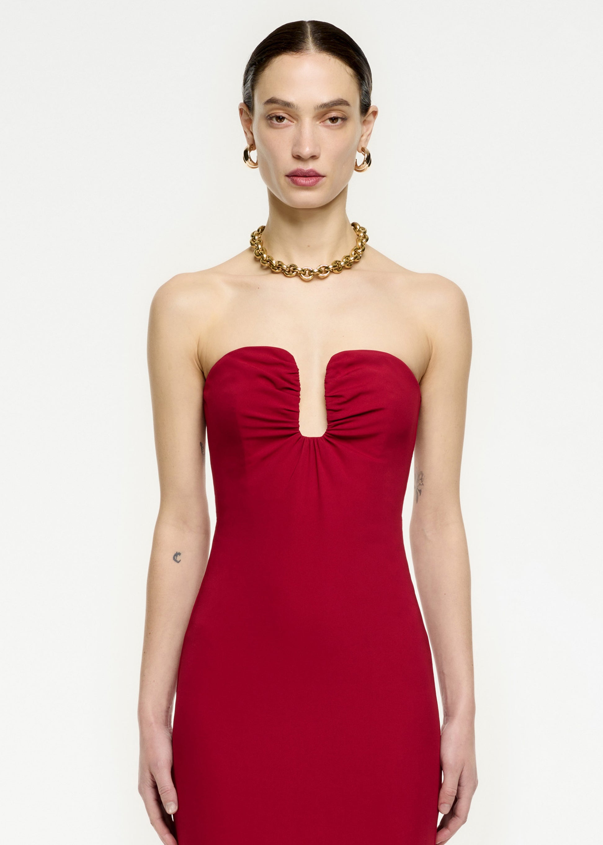 A close up of a woman wearing the Strapless Stretch Cady Maxi Dress in Red