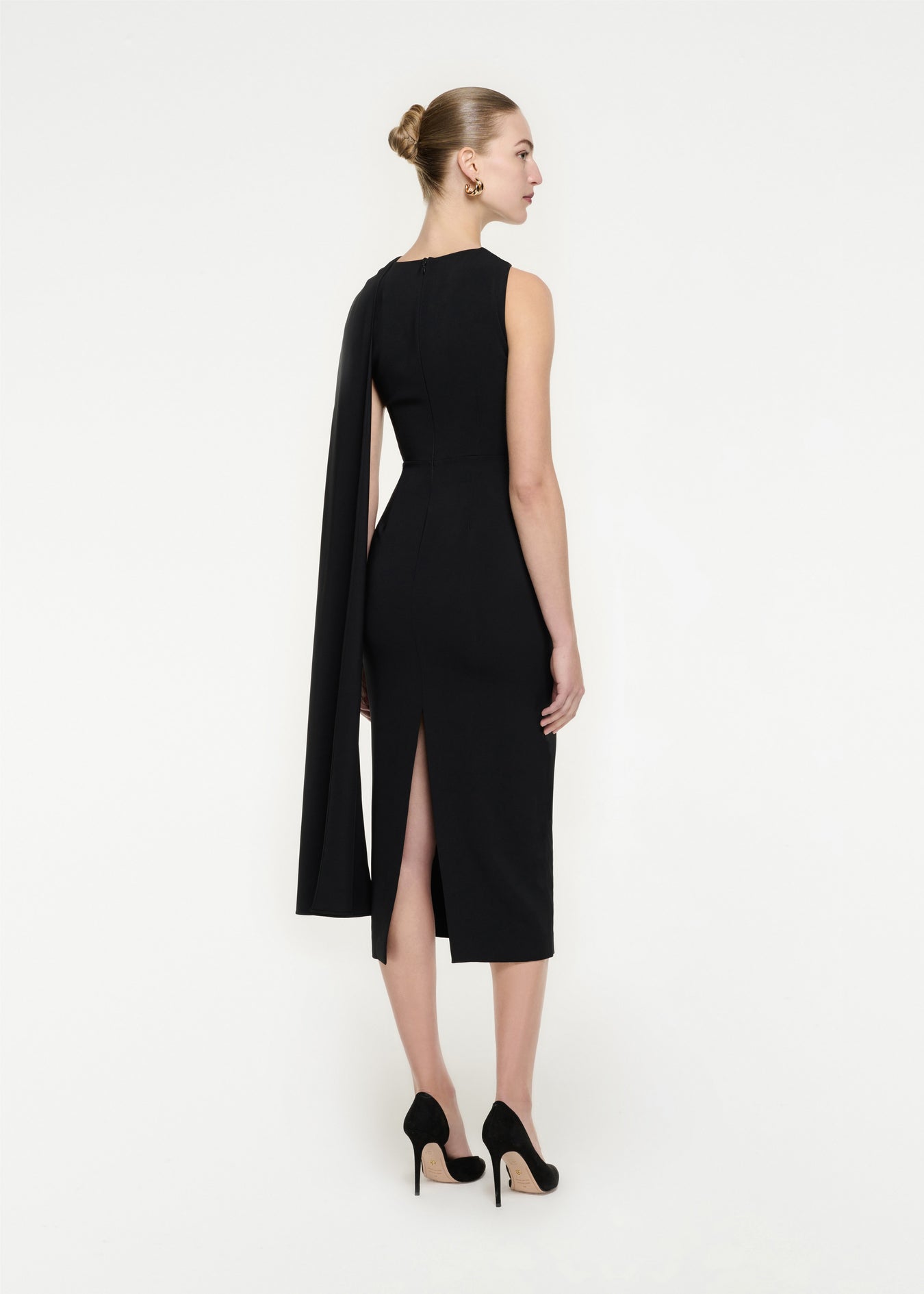 The back of a woman wearing the Asymmetric Stretch Cady Midi Dress in Black