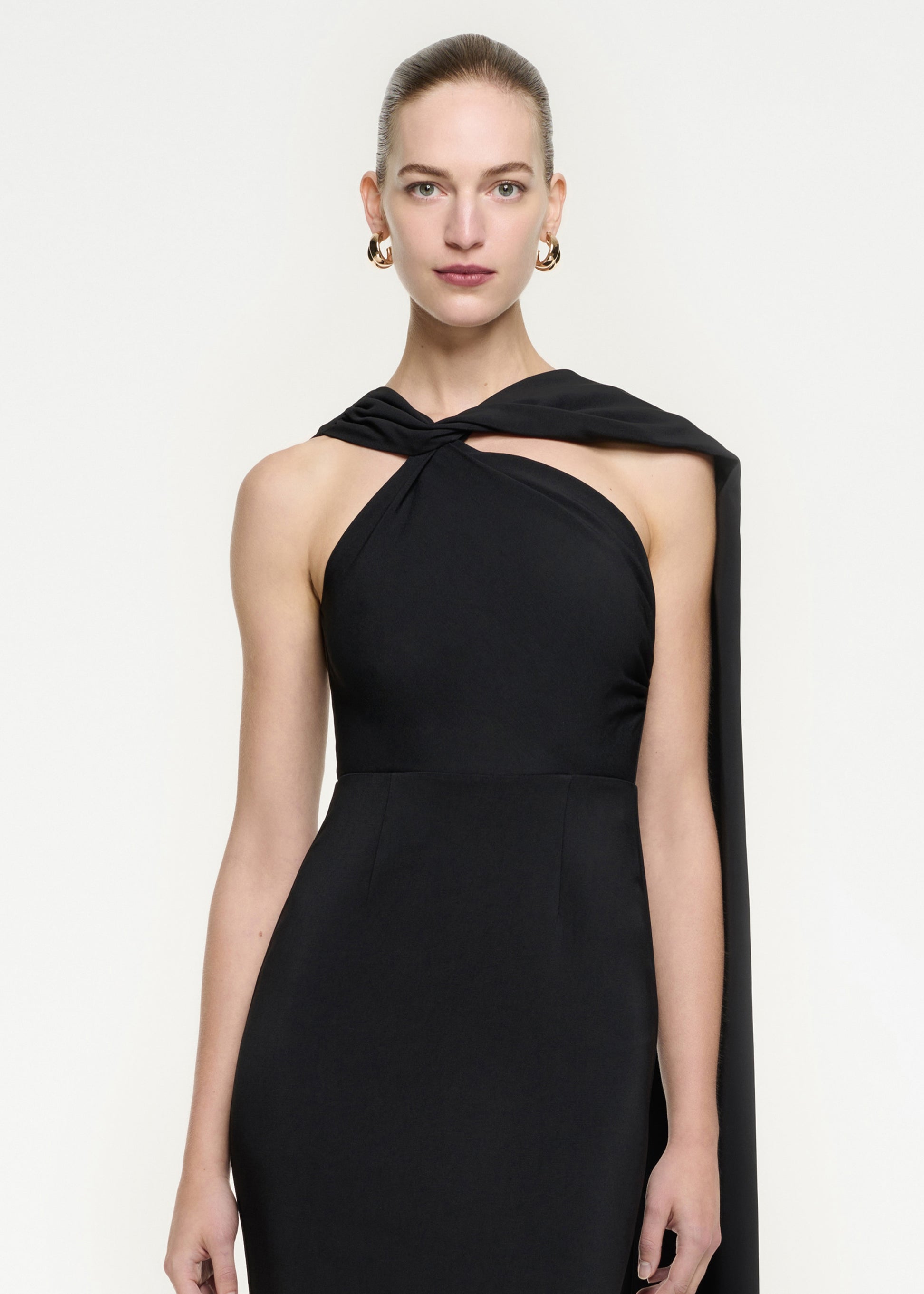 A close up of a woman wearing the Asymmetric Stretch Cady Midi Dress in Black