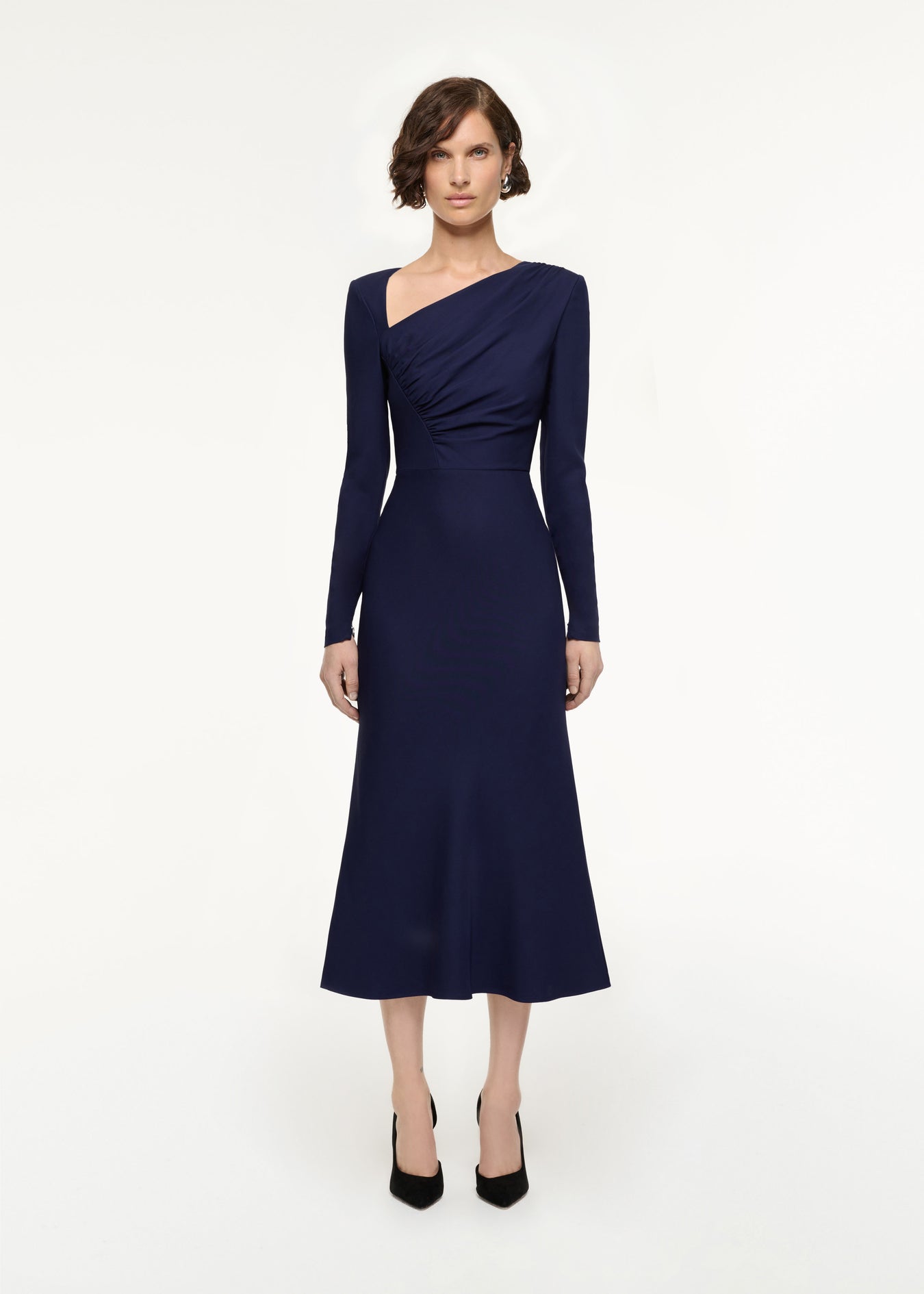 Front view of a model wearing the Asymmetric Drape Stretch Cady Midi Dress in Navy
