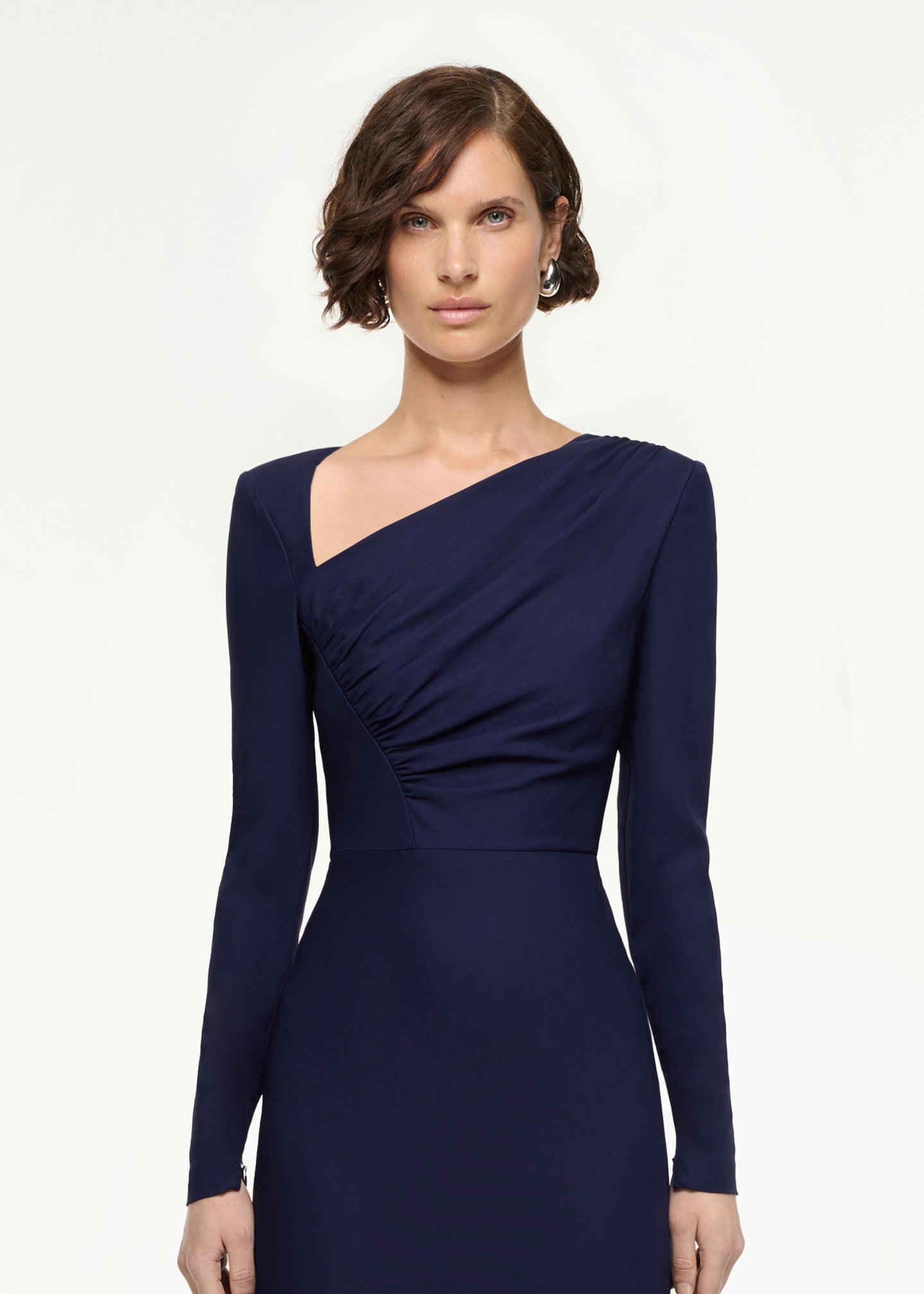 Close up of a model wearing the Asymmetric Drape Stretch Cady Midi Dress in Navy