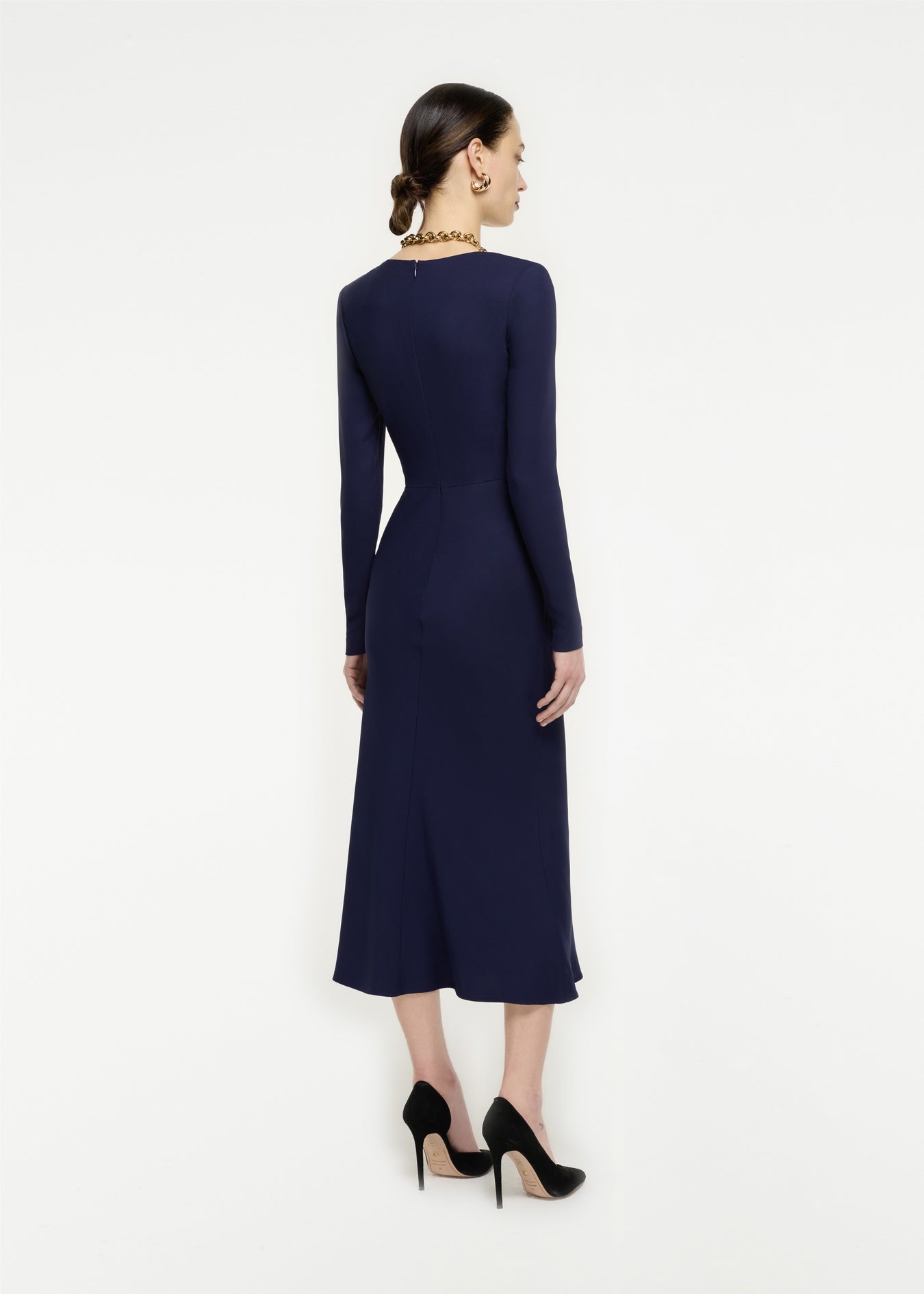 The back of a woman wearing the Long Sleeve Stretch Cady Midi Dress in Navy