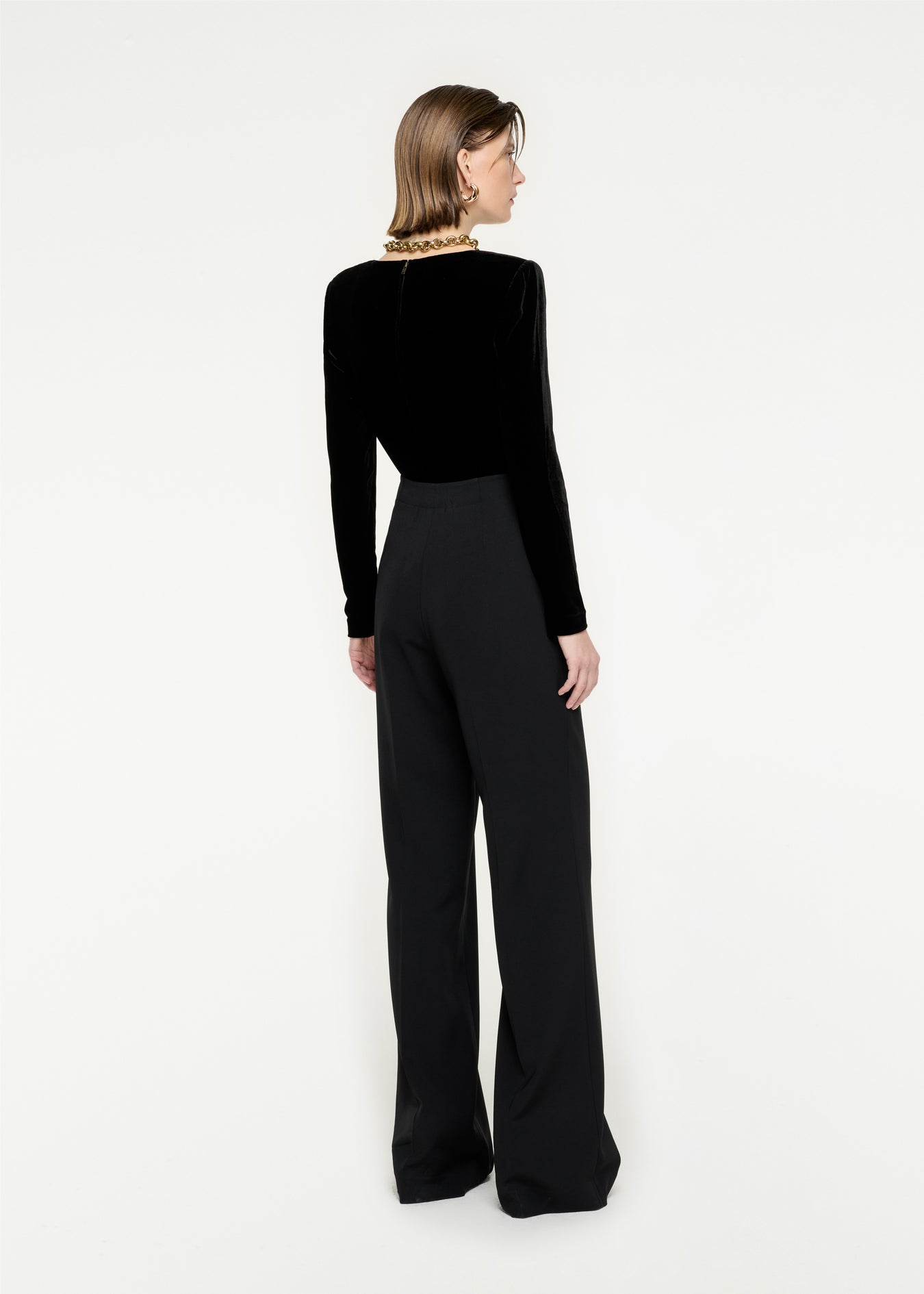 The back of a woman wearing the Long Sleeve Velvet Top in Black