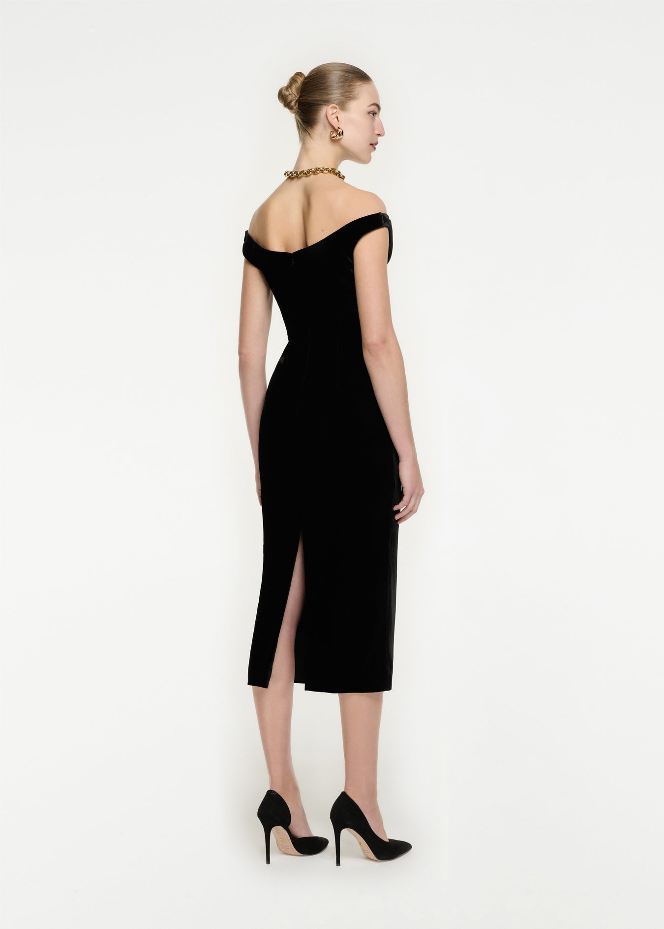 The back of a woman wearing the Off The Shoulder Velvet Midi Dress in Monochrome