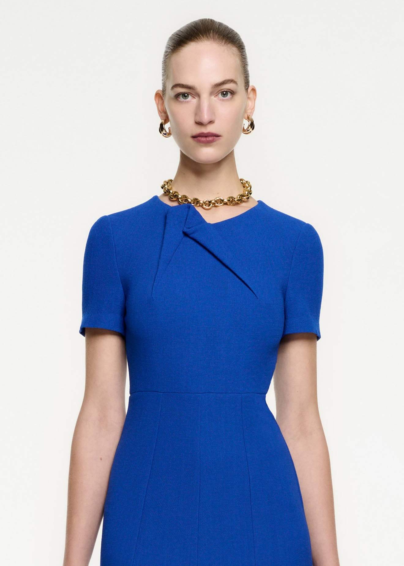 Close up of a model wearing the Short Sleeve Wool Crepe Midi Dress in Blue
