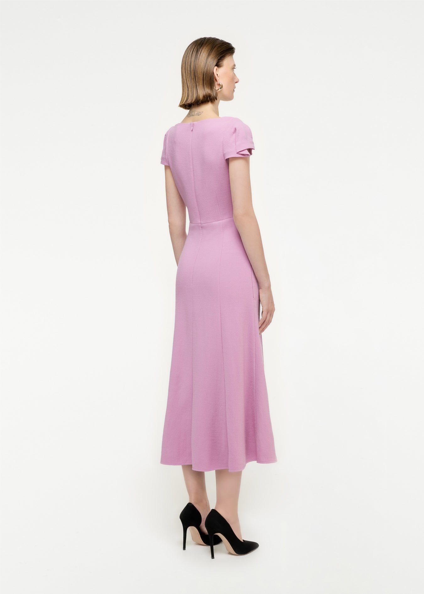 The back of a woman wearing the Cap Sleeve Wool Crepe Midi Dress in Pink