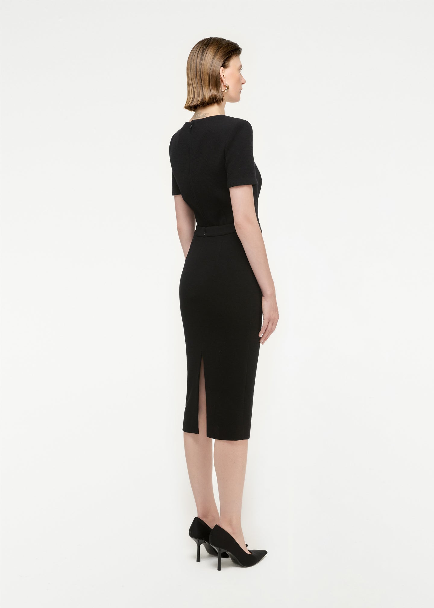 The back of a woman wearing the Wool Crepe Midi Skirt in Black