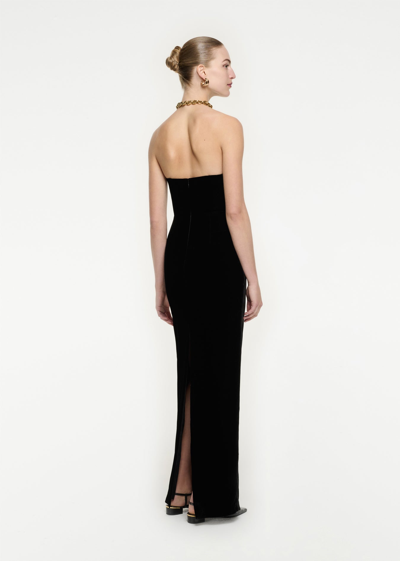 The back of a woman wearing the Strapless Velvet Gown in Black