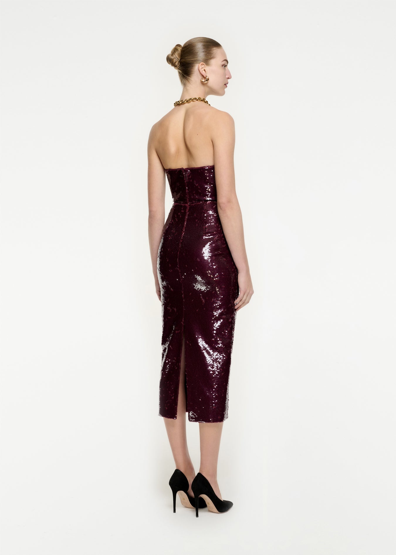 The back of a woman wearing the Strapless Sequin Midi Dress in Maroon