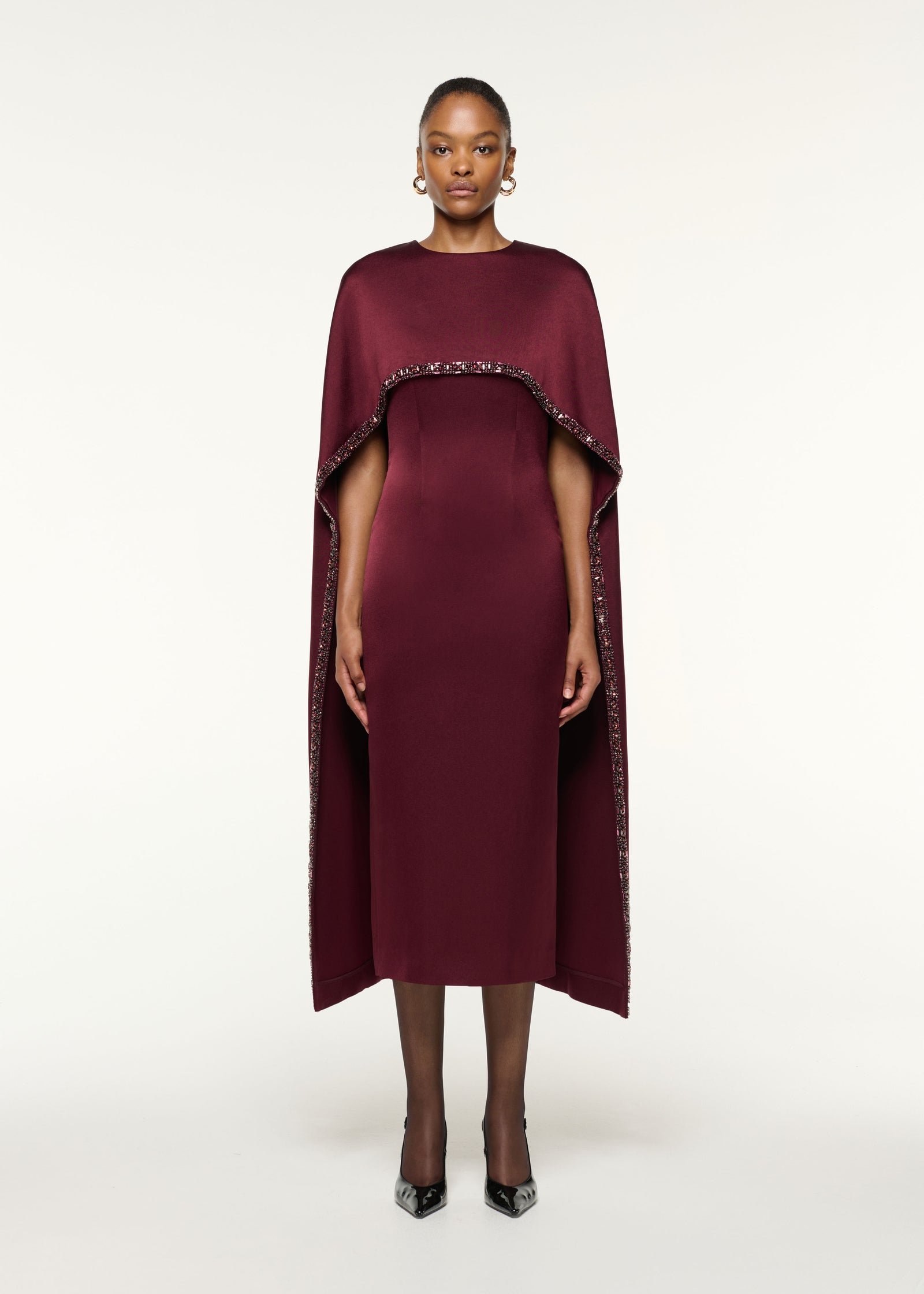 Front view of a model wearing the Crystal Trimmed Cape Midi Dress in Mulberry
