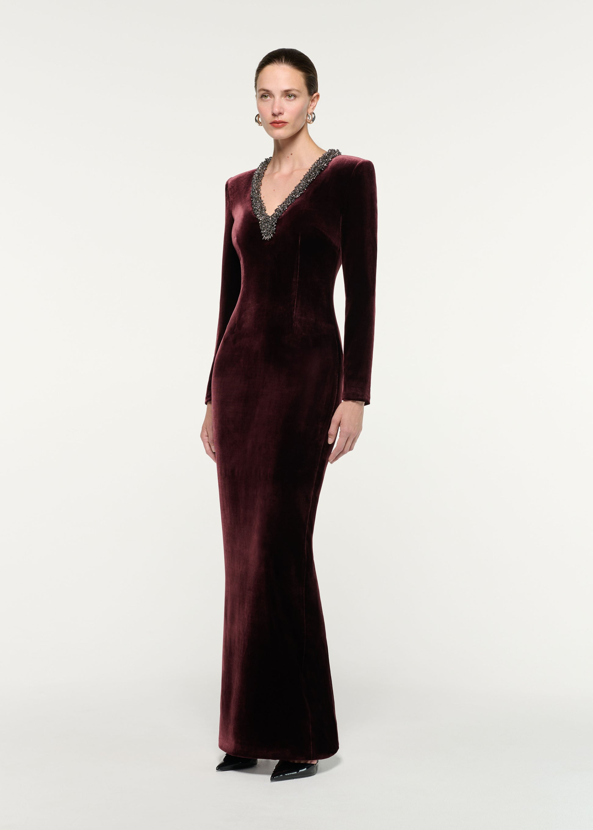 Side view of a model wearing the Long Sleeve Embellished Velvet Gown