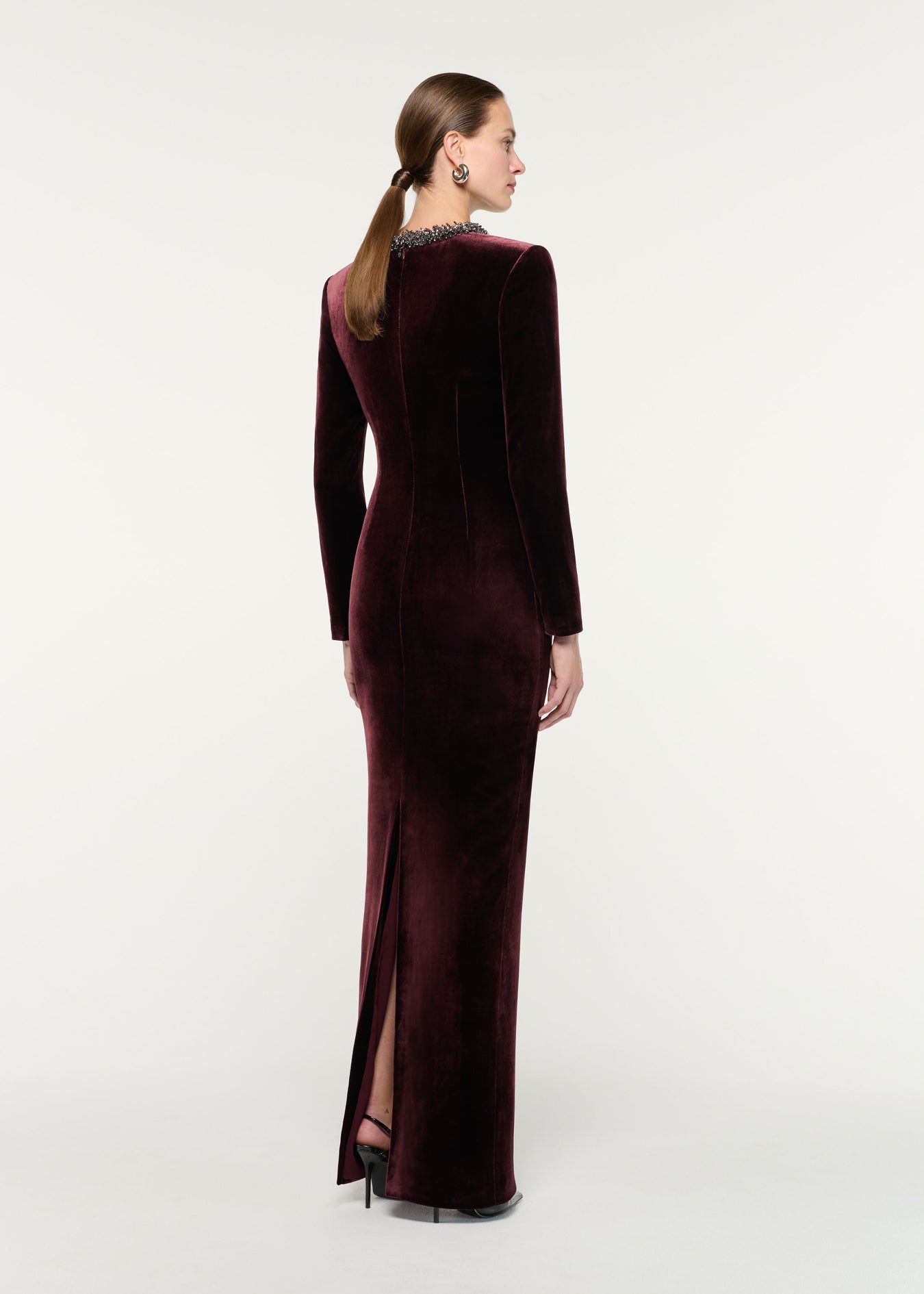Back view of a model wearing the Long Sleeve Embellished Velvet Gown