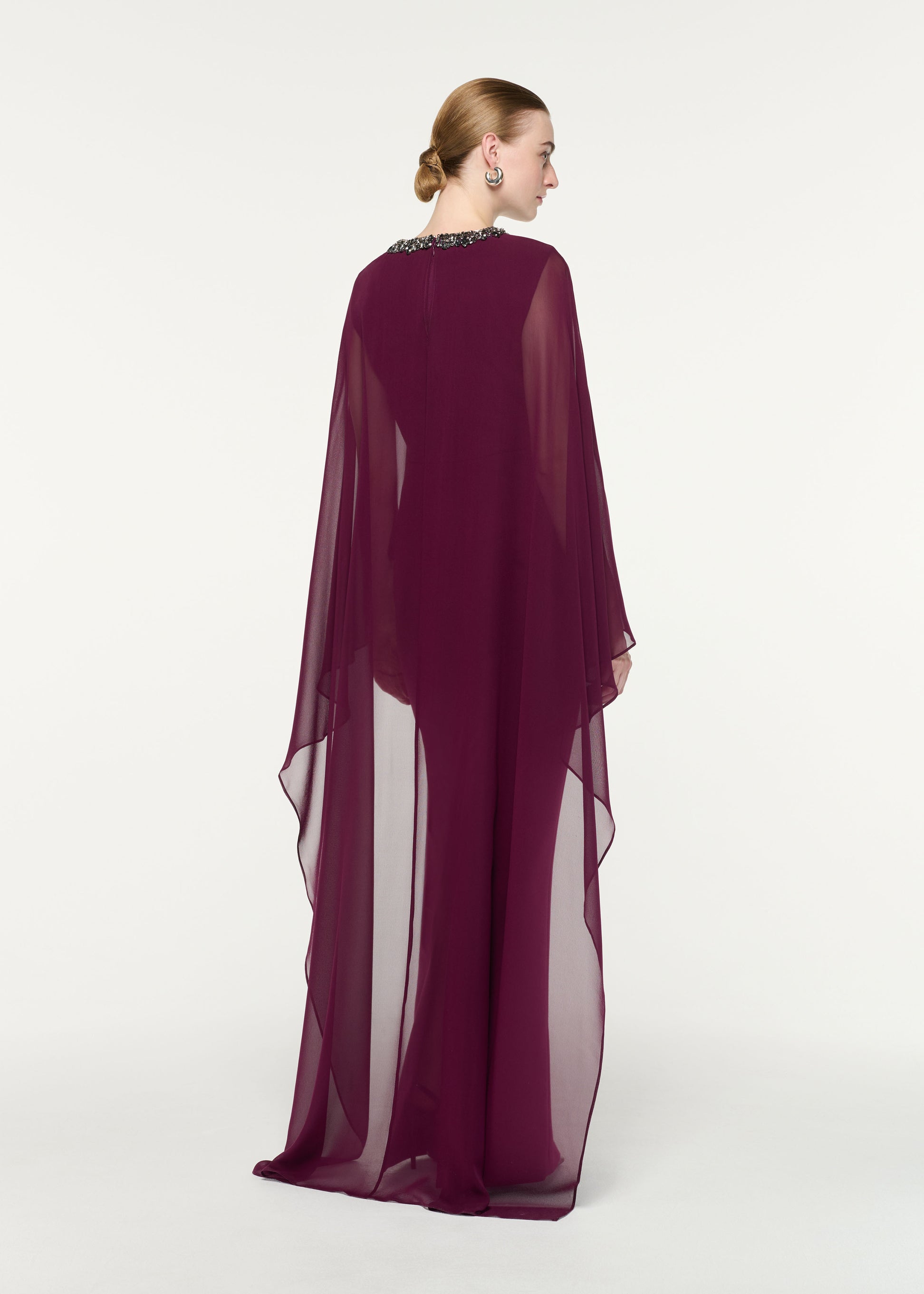 Back view of a model wearing the Embellished Chiffon Cape Gown