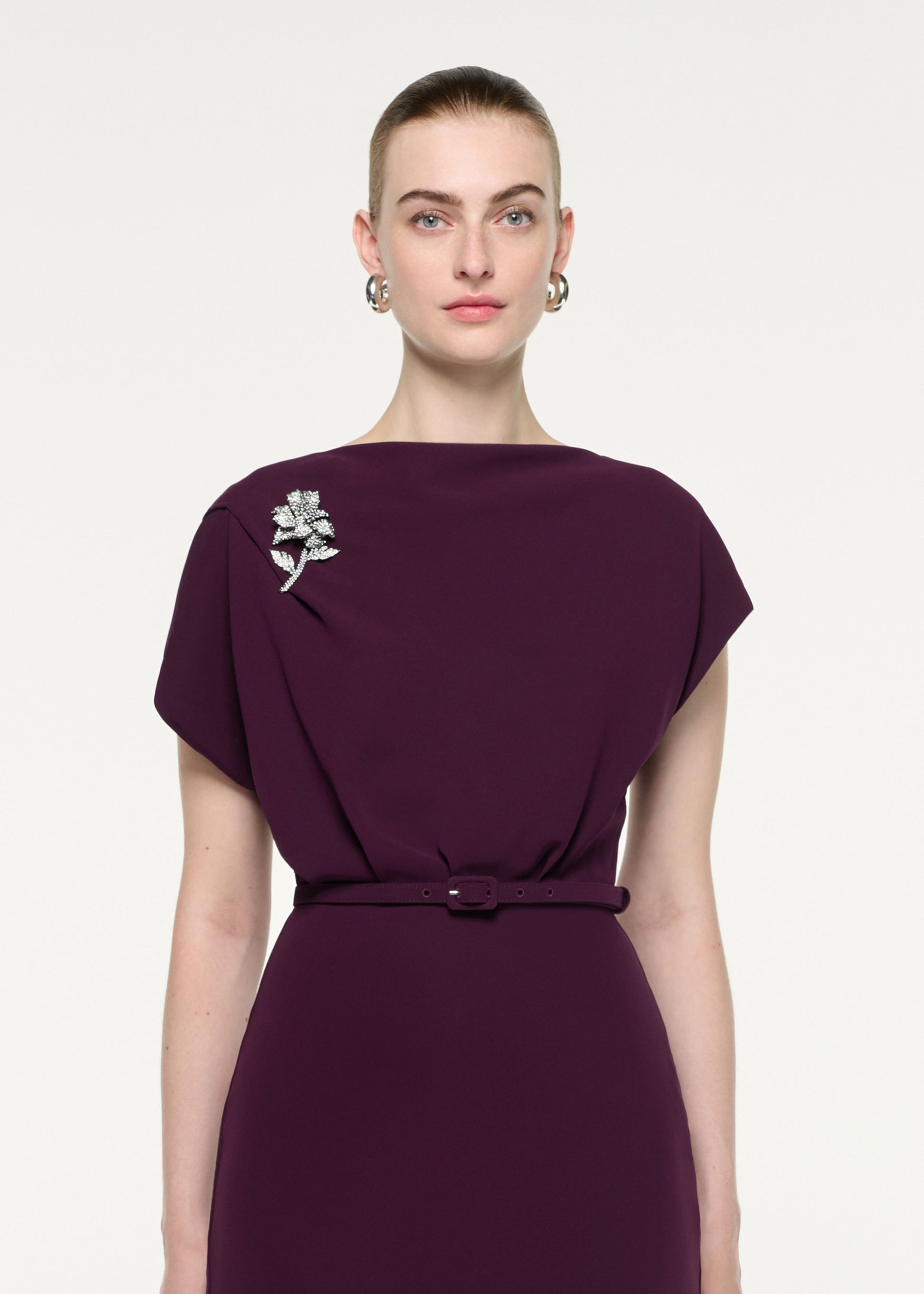 Close up of a model wearing the Flower Brooch Cady Midi Dress