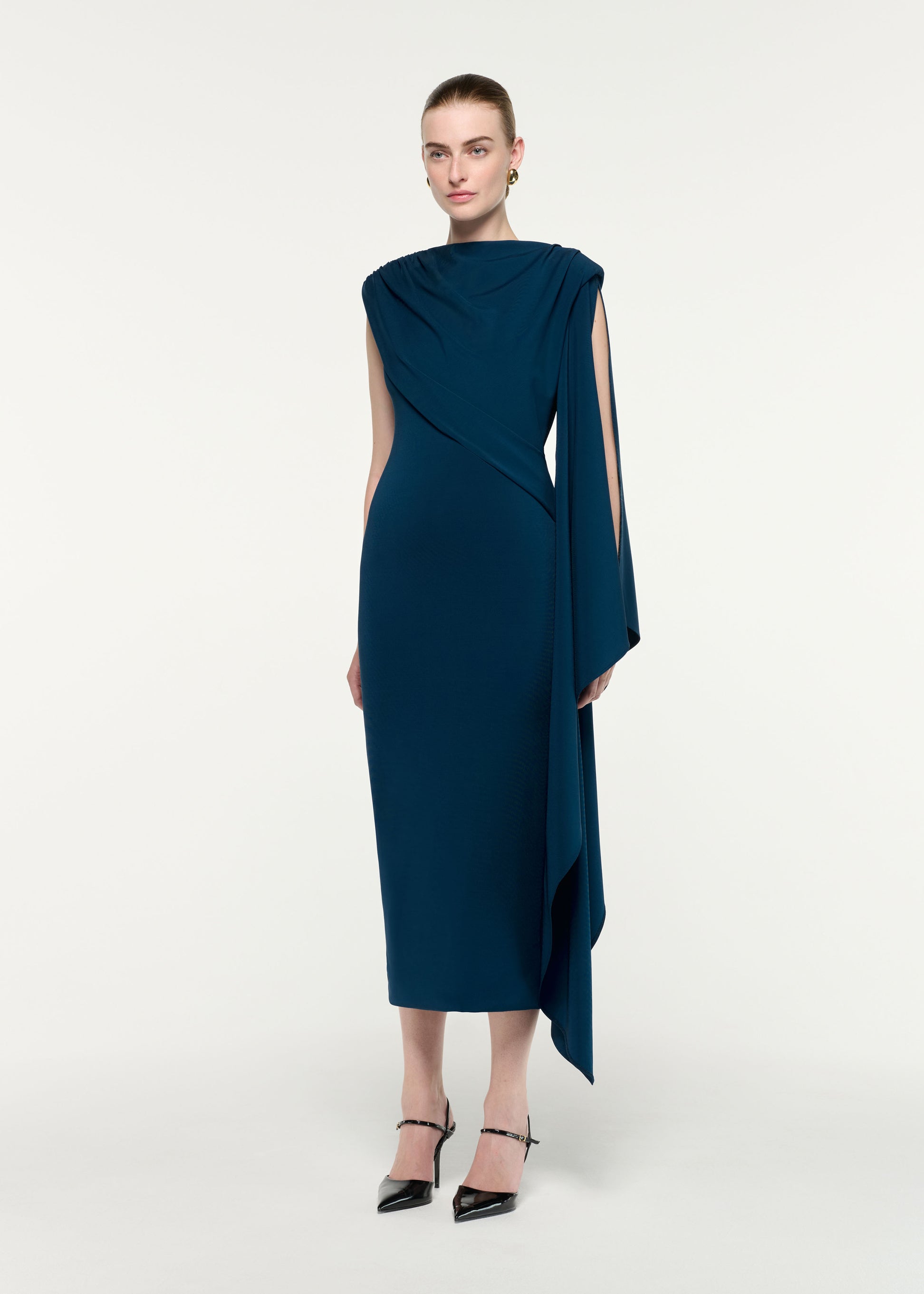 Side view of a model wearing the Asymmetric Cape Jersey Midi Dress