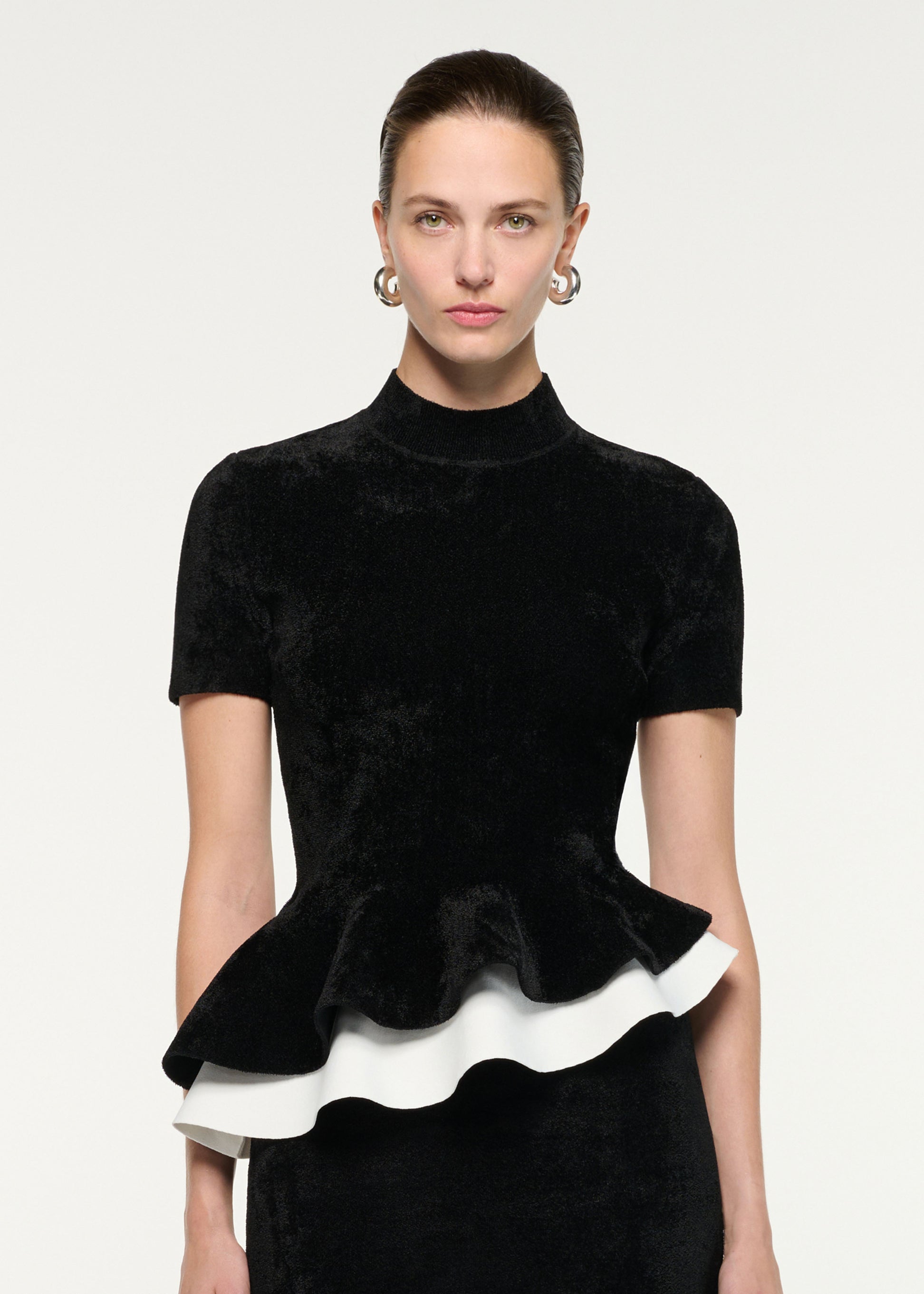 Close up of a model wearing the Short Sleeve Chenille Peplum Midi Dress