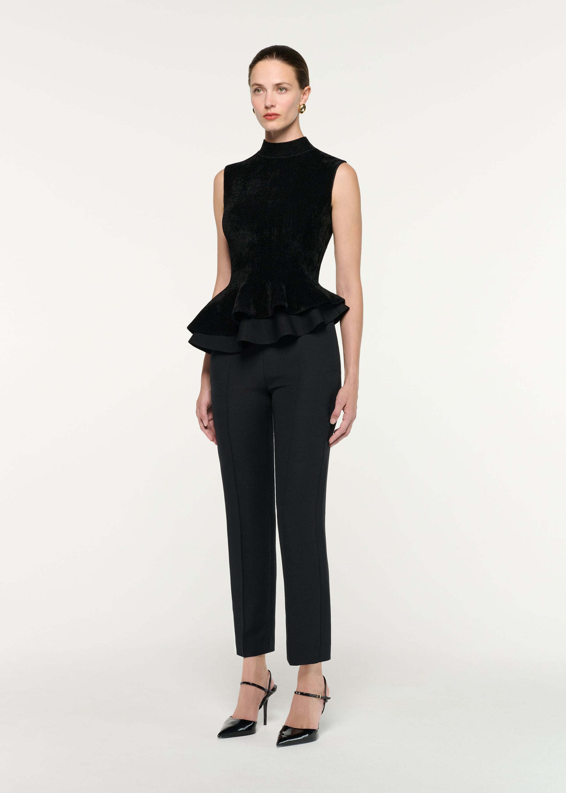 Side view of a model wearing the Sleeveless Chenille Knit Peplum Top