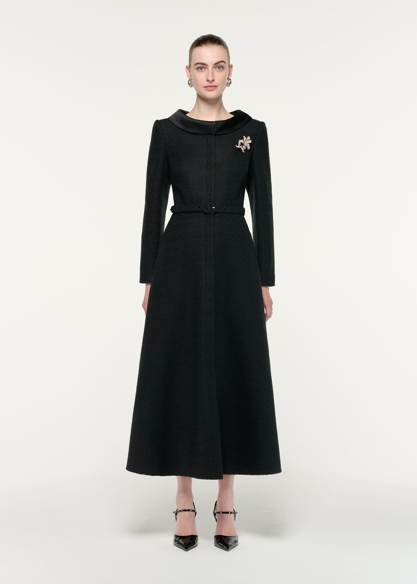 Front view of a model wearing the Boucle Coat With Flower Brooch