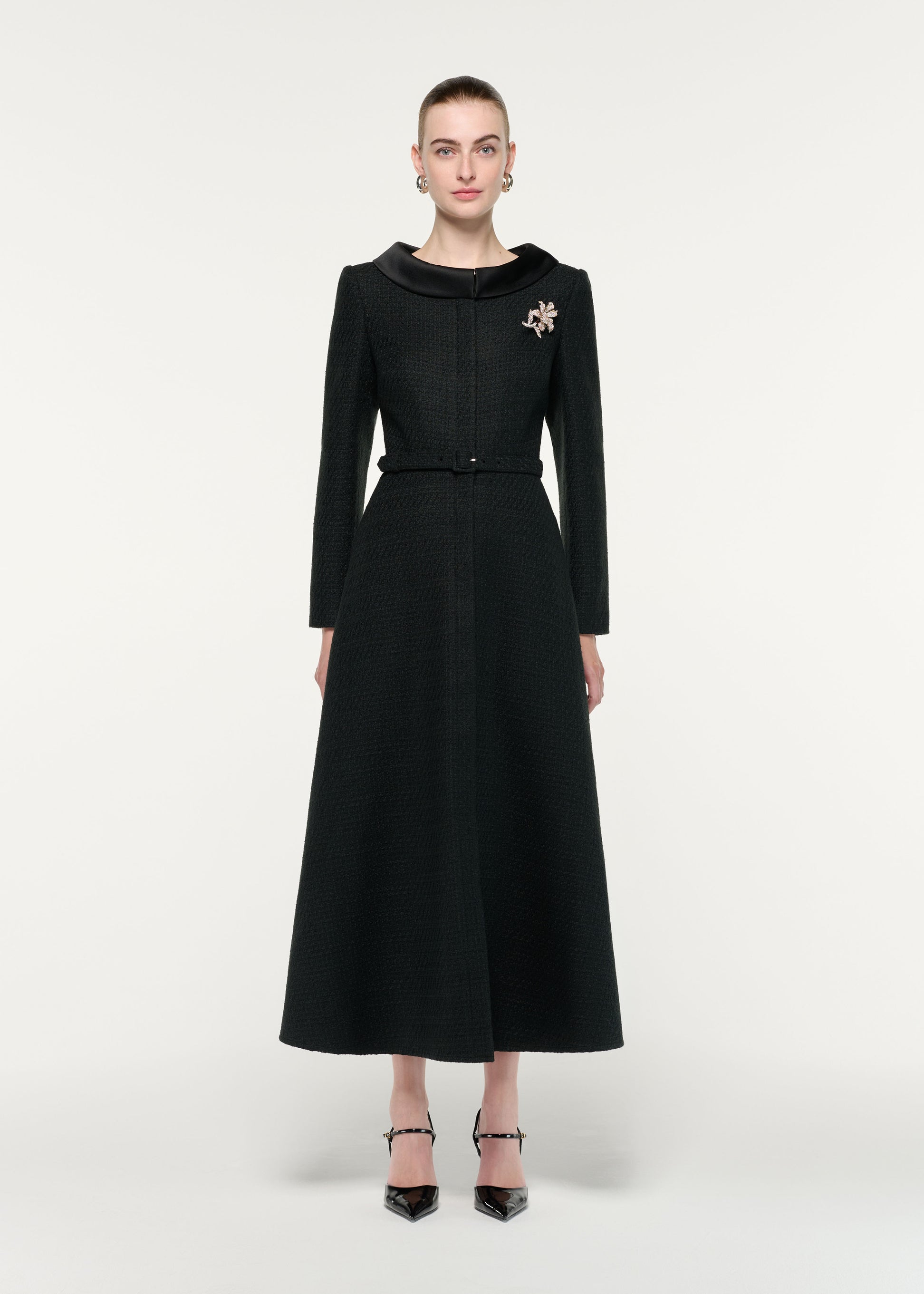 Front view of a model wearing the Boucle Coat With Flower Brooch