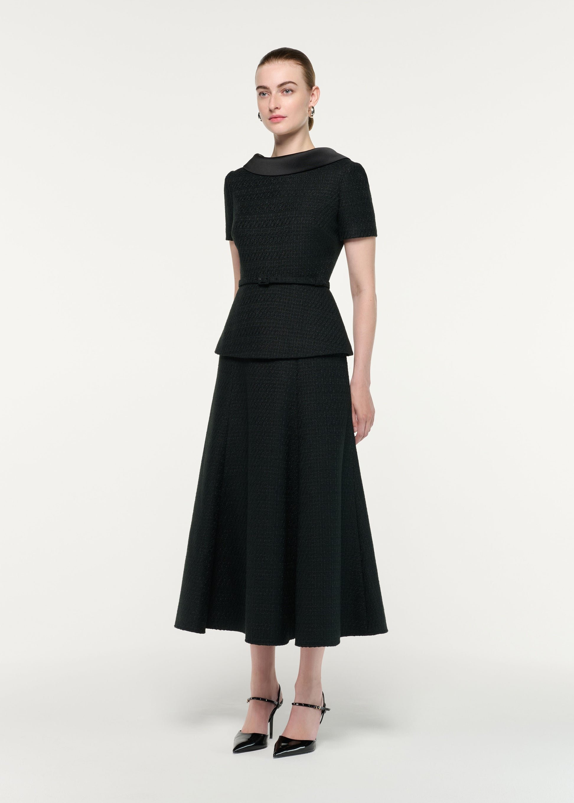 Side view of a model wearing the Collared Boucle Peplum Midi Dress