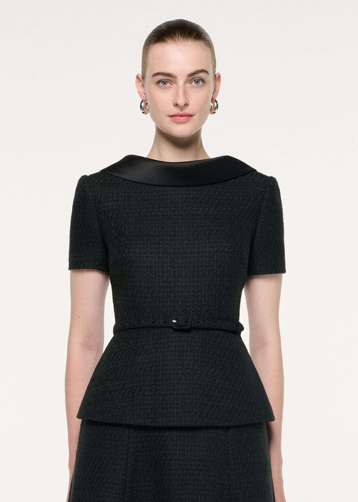 Close up of a model wearing the Collared Boucle Peplum Midi Dress
