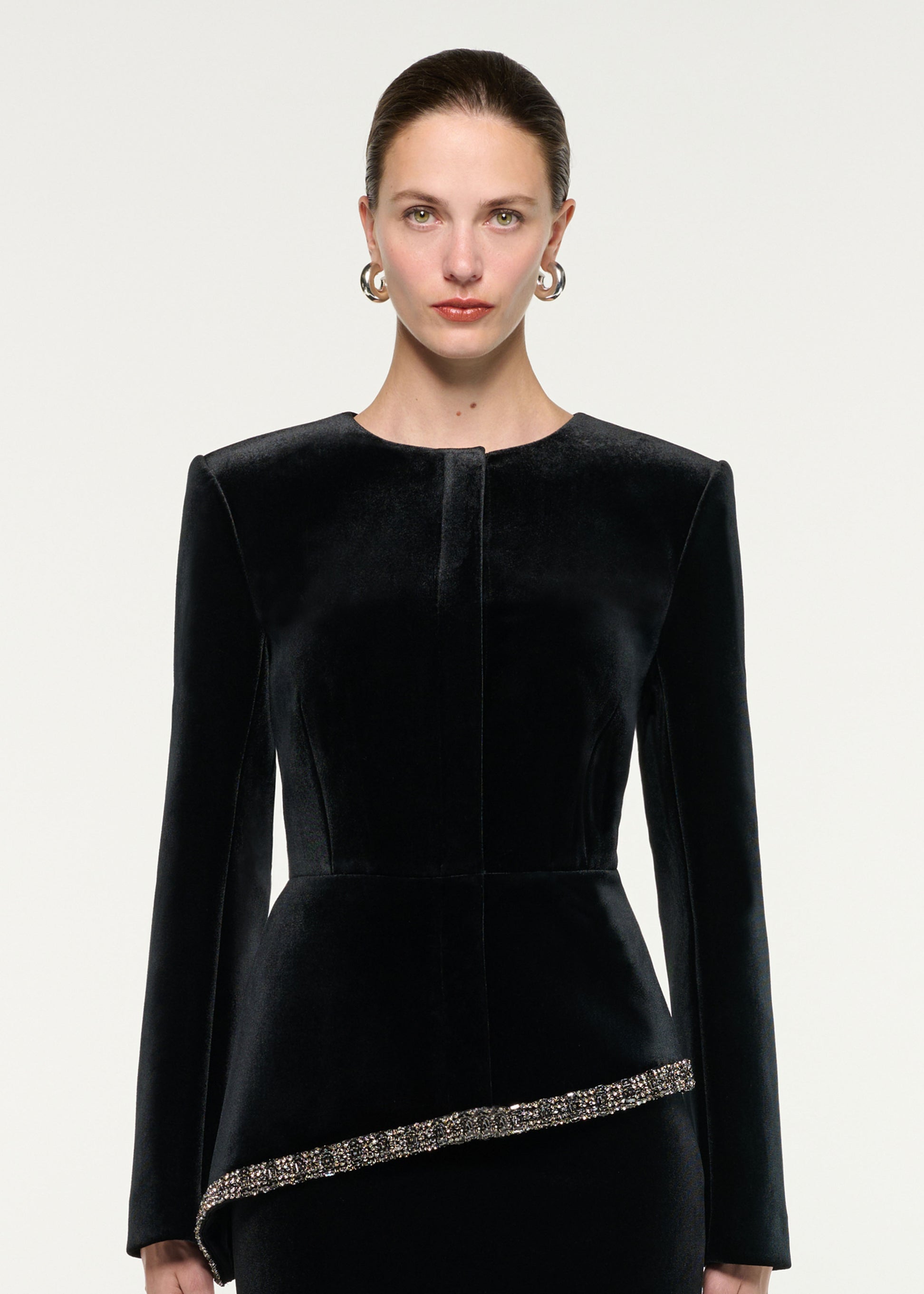 Close up of a model wearing the Velvet Embellished Trim Peplum Jacket