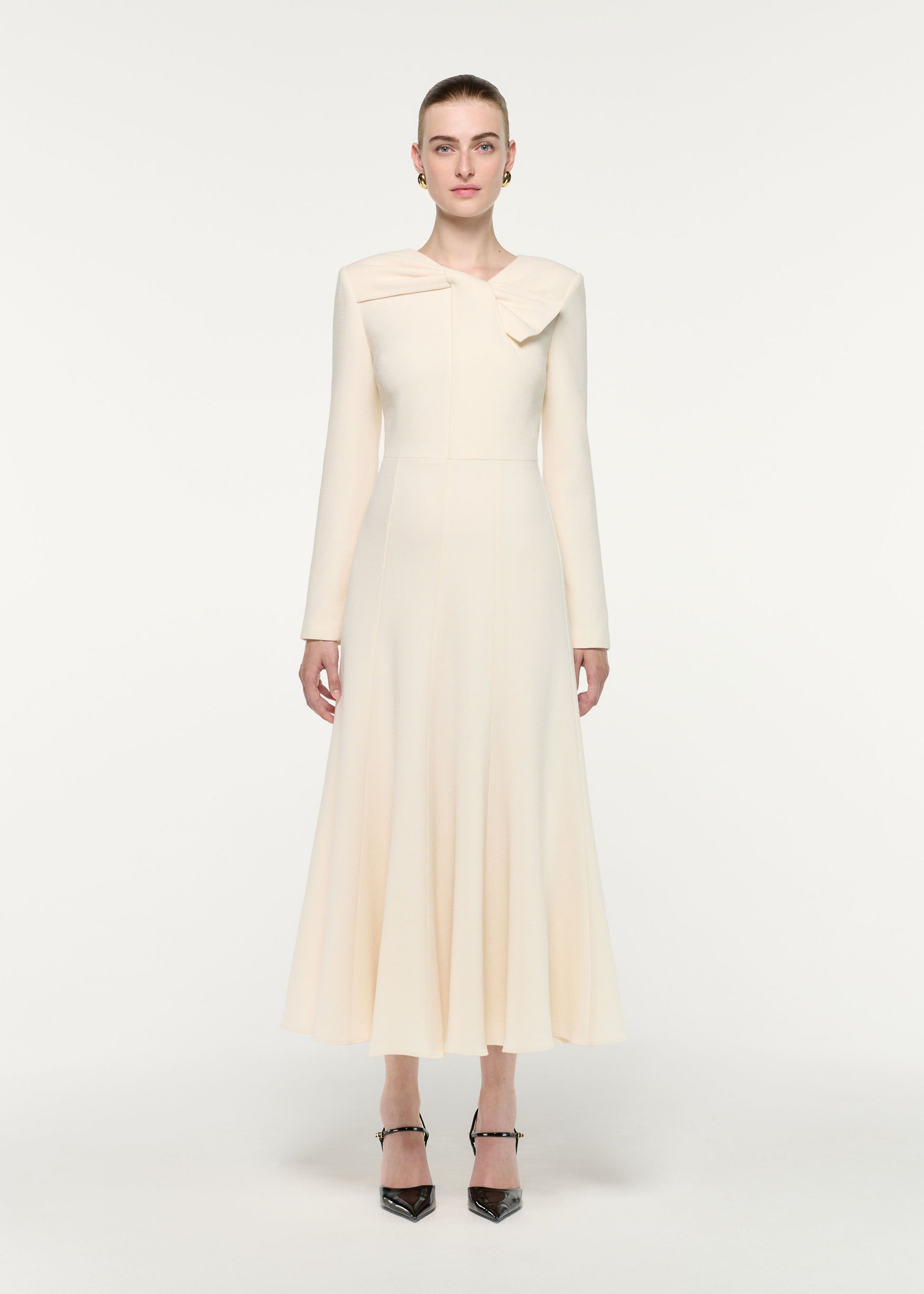 Front view of a model wearing the Asymmetric Bow Neck Wool Crepe Midi Dress