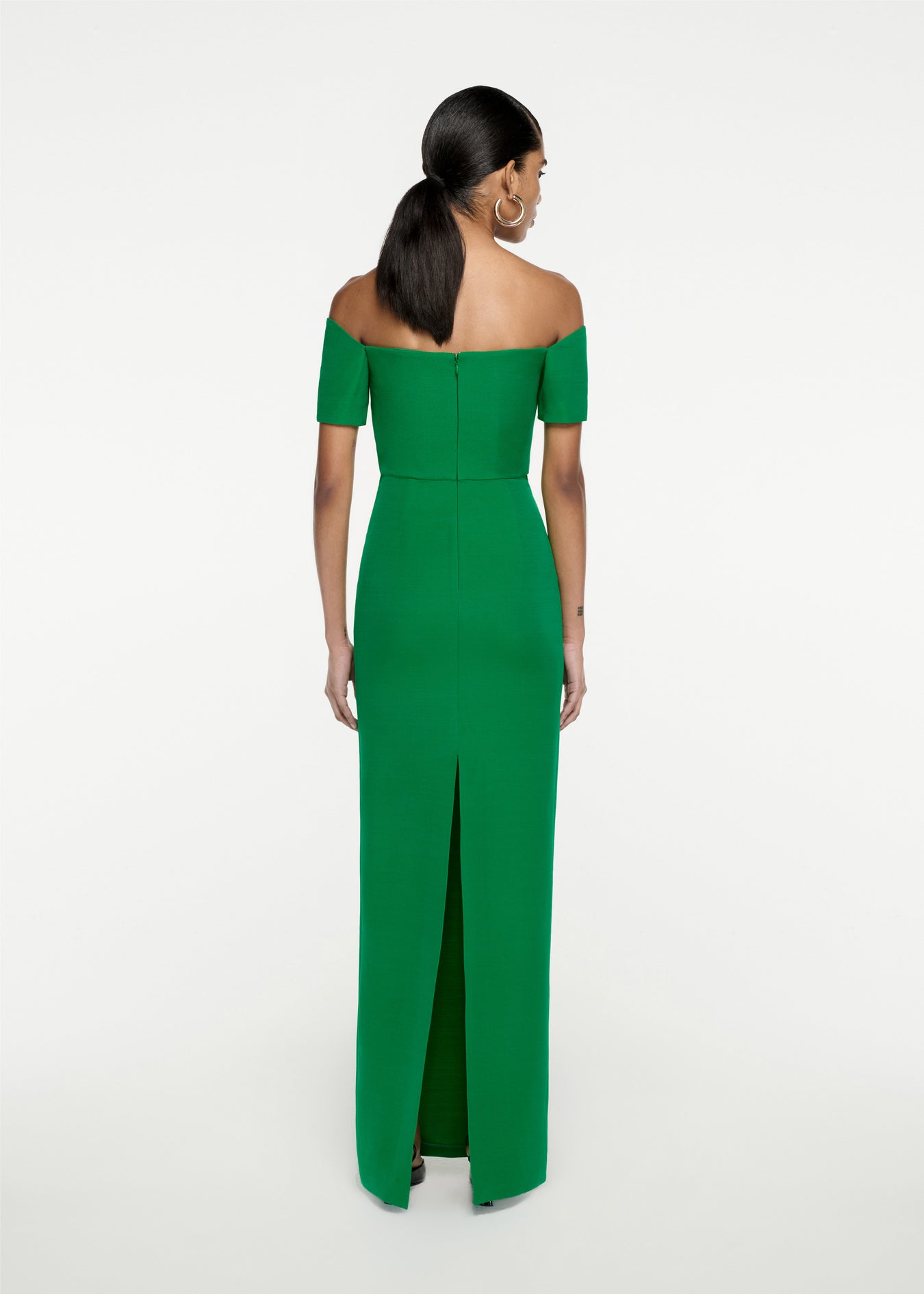 The back of a woman wearing the Asymmetric Silk Wool Maxi Dress in Green