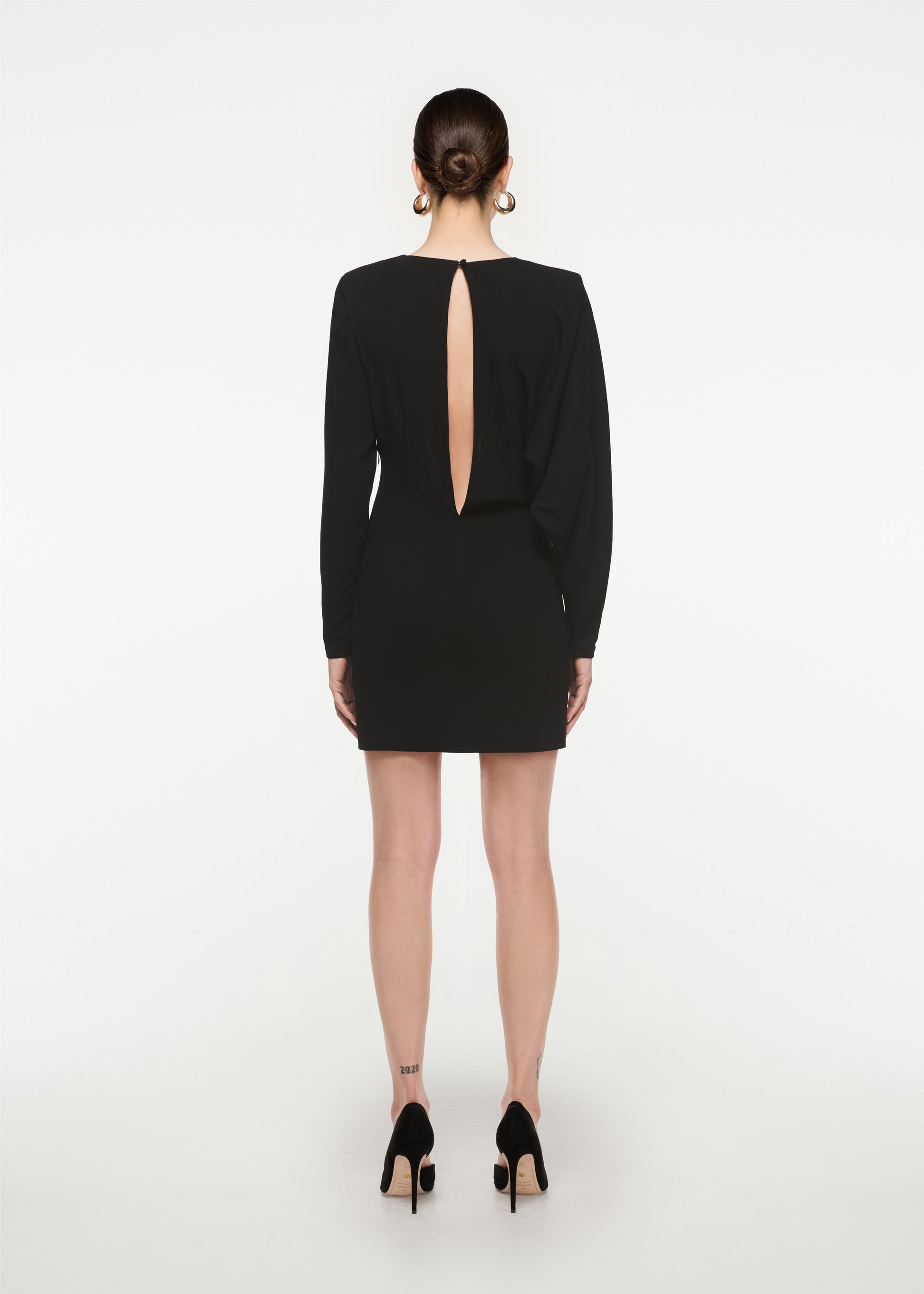 The back of a woman wearing the Long Sleeve Stretch Cady Mini Dress in Black