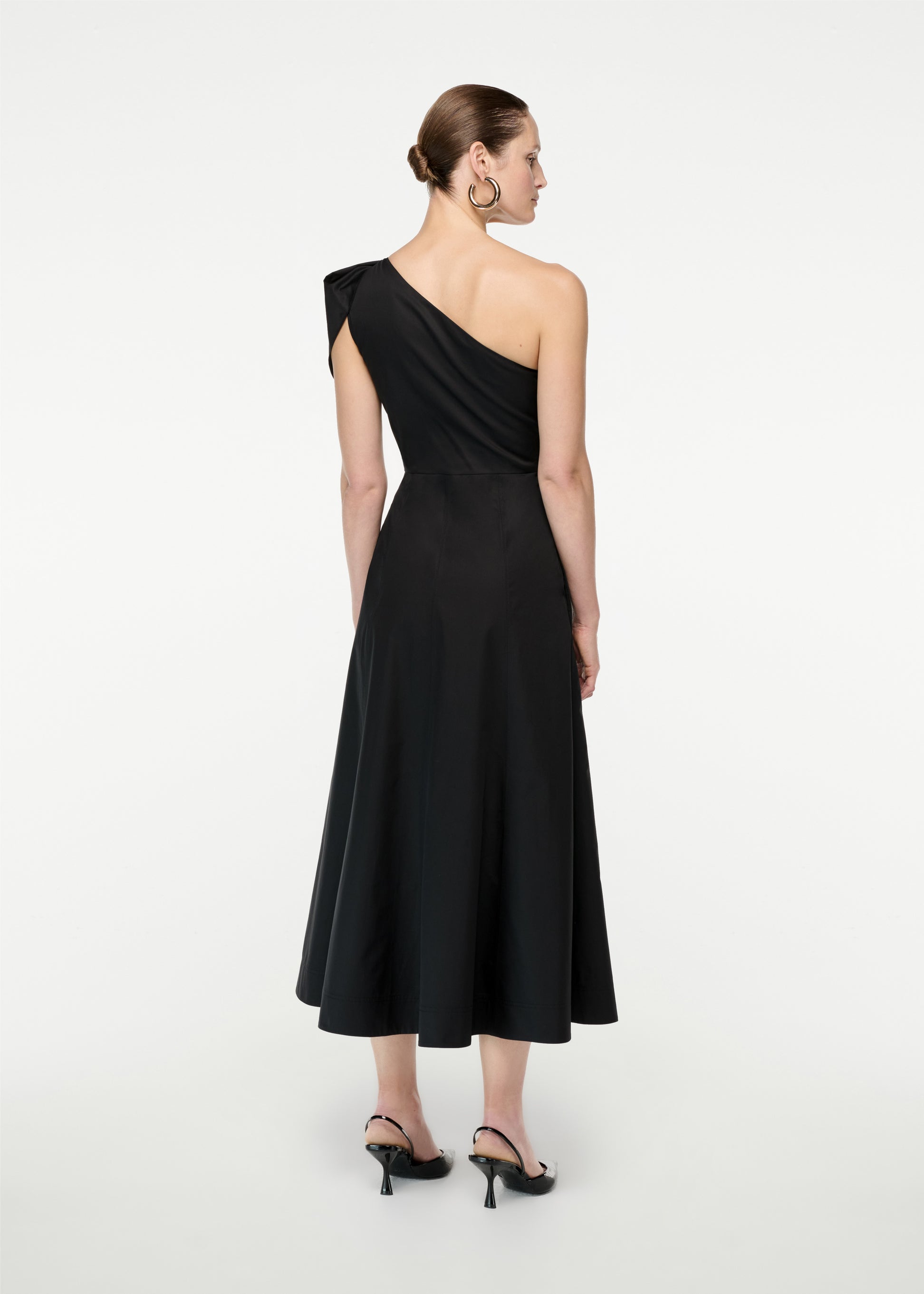 The back of a woman wearing the Asymmetric Cotton Poplin Midi Dress in Black