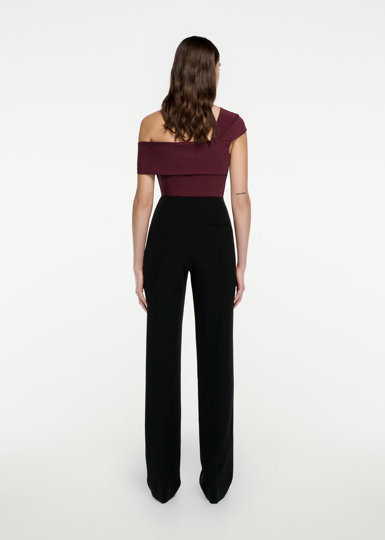 The back of a woman wearing the Asymmetric Stretch Cady Top in Maroon